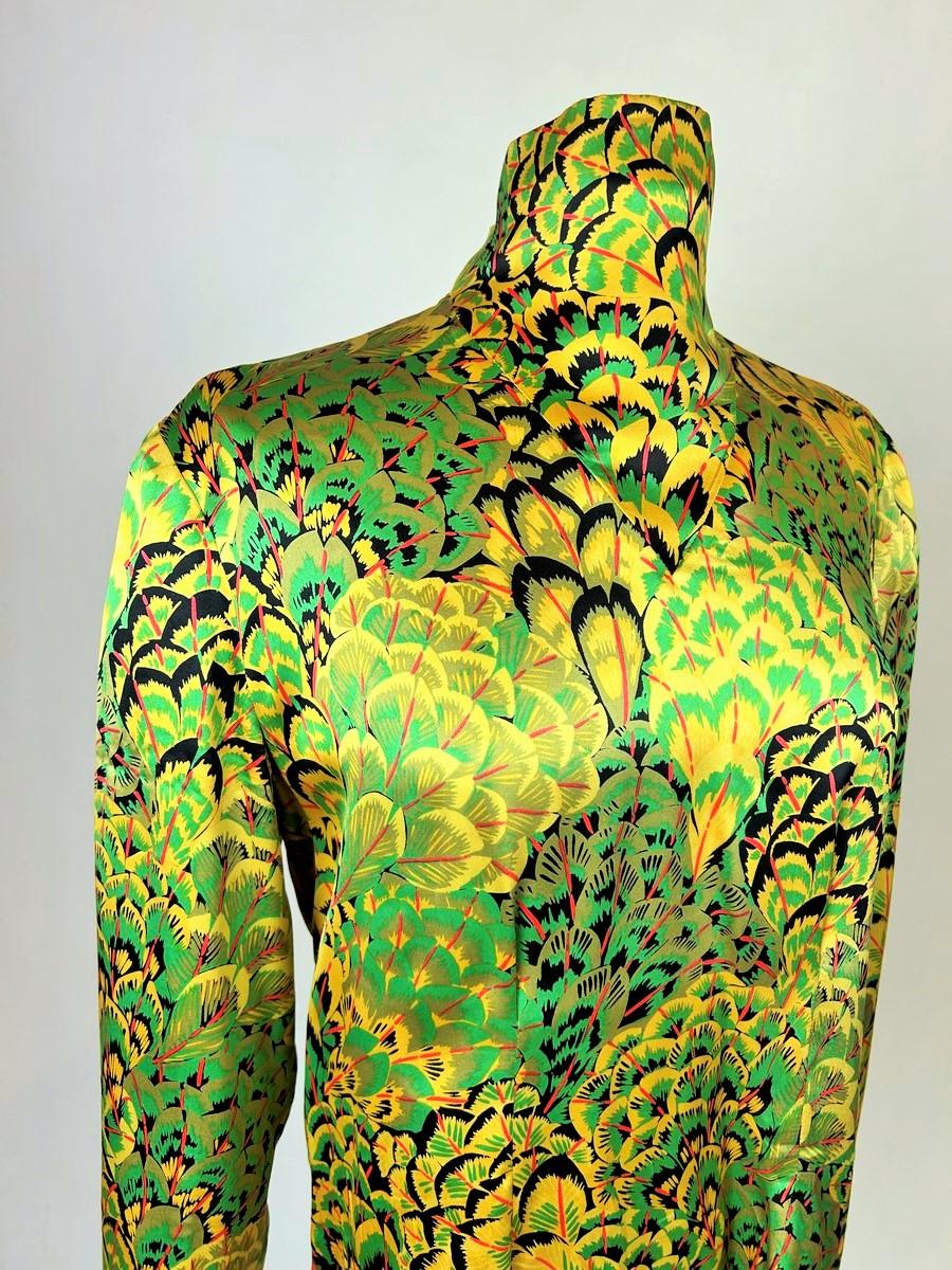 Circa 1980
France
Evening blouse in printed silk satin by Pierre Balmain Haute Couture dating from the 1980s. Amazing print on silk forming fans of peacock feathers (?) in shades of green, yellow, black, grey, red and yellow. Straight and fluid cut,