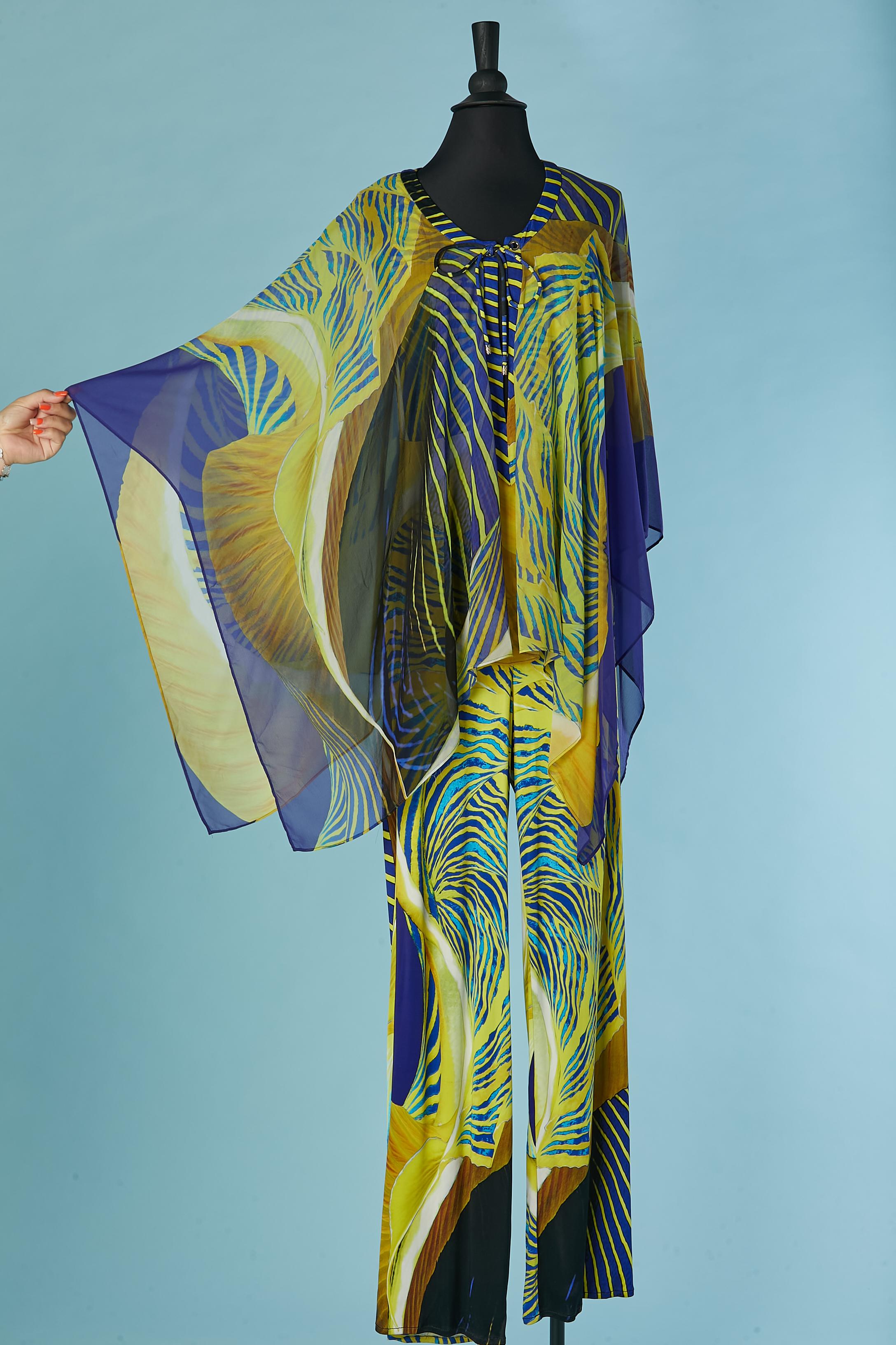 Printed sleeveless jumpsuit with silk printed poncho. Main fabric composition: 100% rayon. Poncho composition: 100% silk ( branded)
Zip closure on the left side with branded zip puller + hook&eye. Branded button closure on the Poncho middle front +