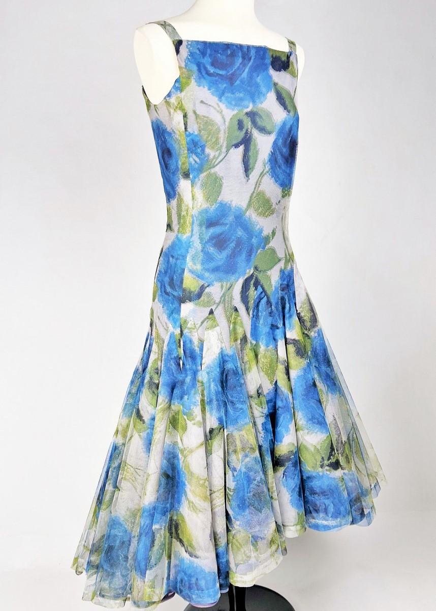  Circa 1956

France

A summer evening dress by Nina Ricci Haute Couture under the direction of Madame Brossin de Méré dating from 1955-1957. Sleeveless dress with a small bare back held in place by straps. Skilful cut with large tulle bouillonnés
