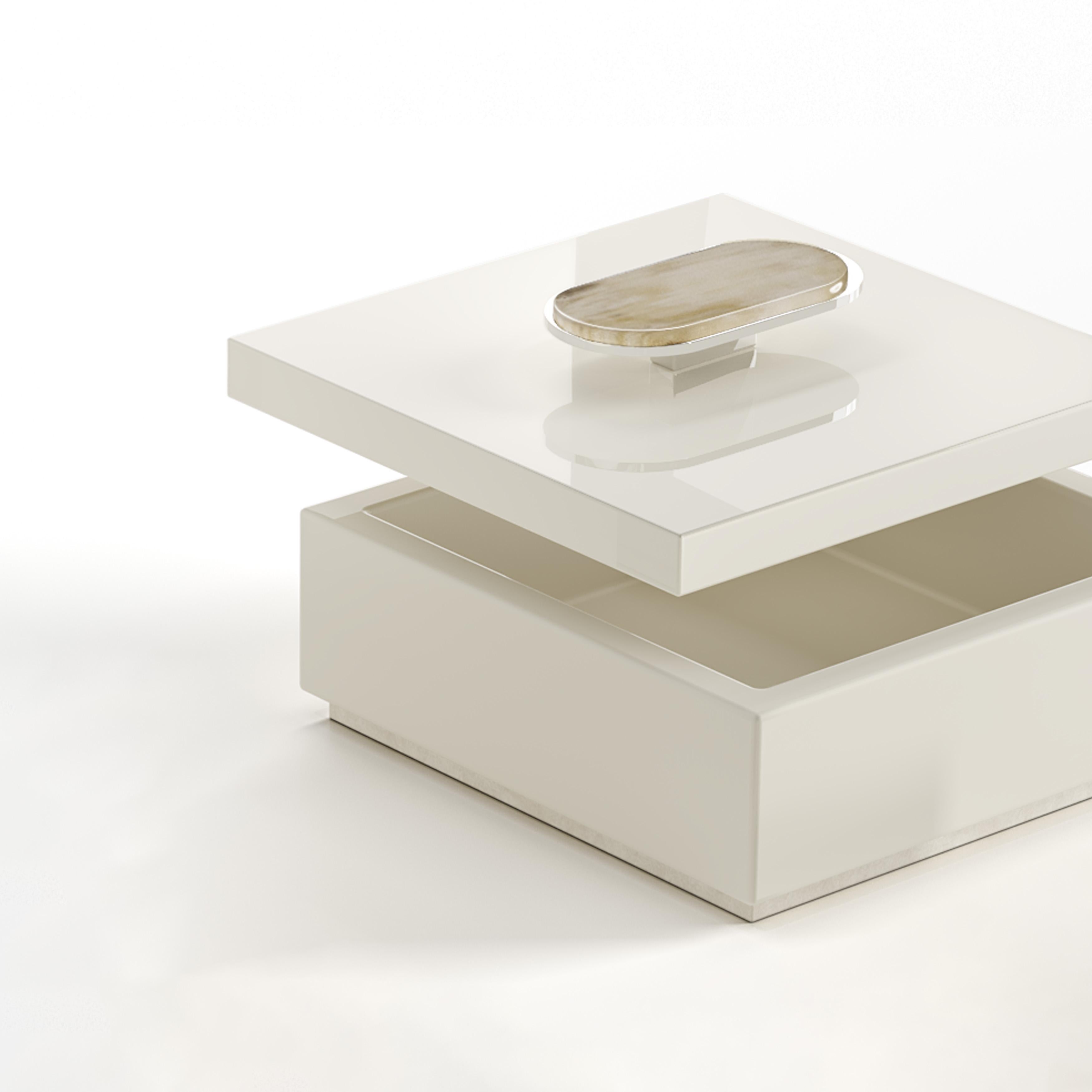 The Priora box is a versatile and elegant accessory, crafted to store your cherished items with the utmost care. Fashioned from glossy ivory lacquered wood, the box is distinguished by the detail in Corno Italiano and chromed brass on the lid,