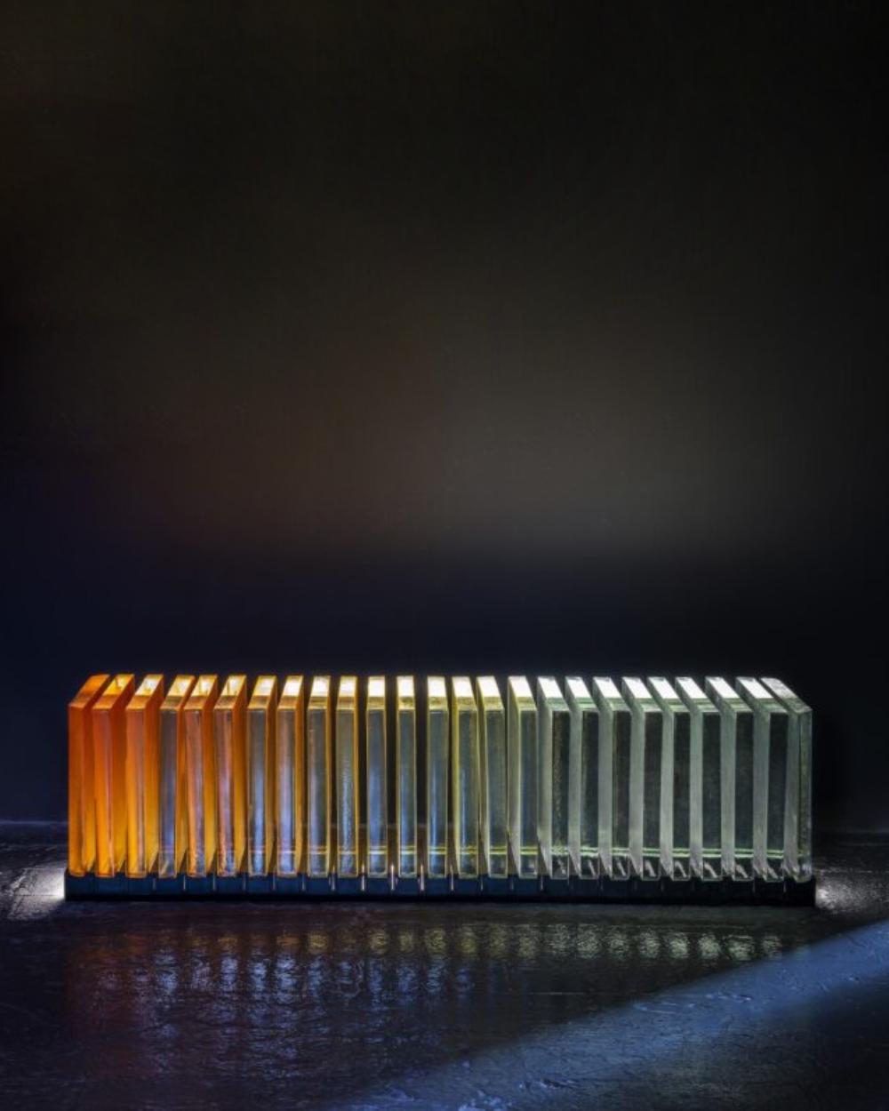 Prism’s characteristic ombre of vibrantly coloured cast glass slabs gradually transition to absolute transparency. Inspired by the refractive quality of the vital prism, light bounces between and suffuses through panels, creating its own internal