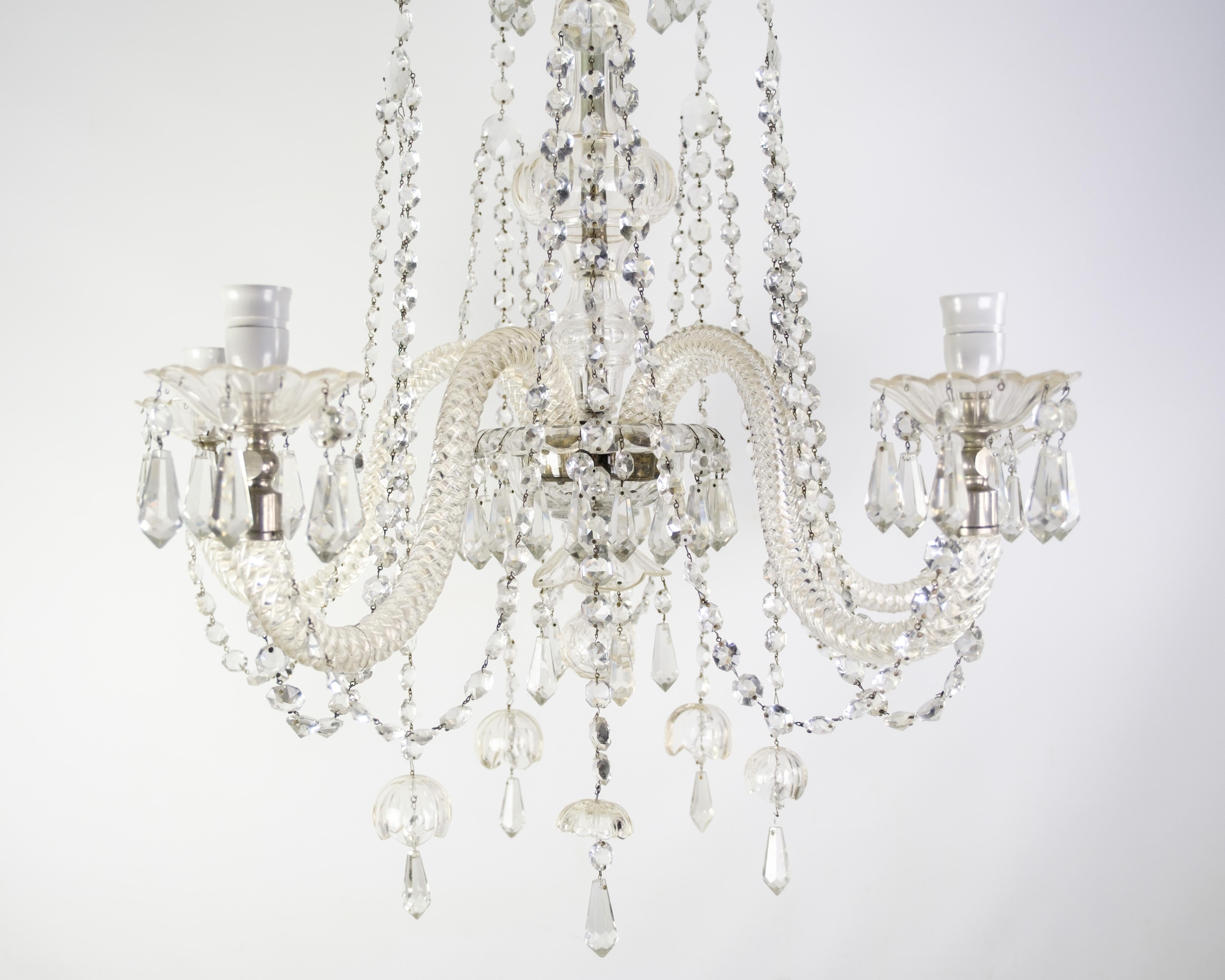 Grand lustre à prisme à cinq bras de verre avec source de lumière électrique datant des années 1930. Elle possède de nombreux prismes magnifiques et est en très bon état.

Dimensions en cm : H:100cm D:85 cm
