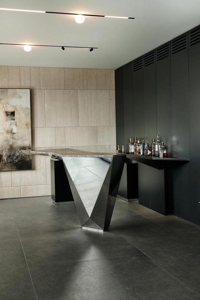 Imposing counter bar characterized by its sculptural futuristic design, massive yet aerial thanks to the reflections on its polished surface.
By Georges Amatoury Studio, 2018.
Polished stainless steel, g metal gray, travertine marble.

(Shipped