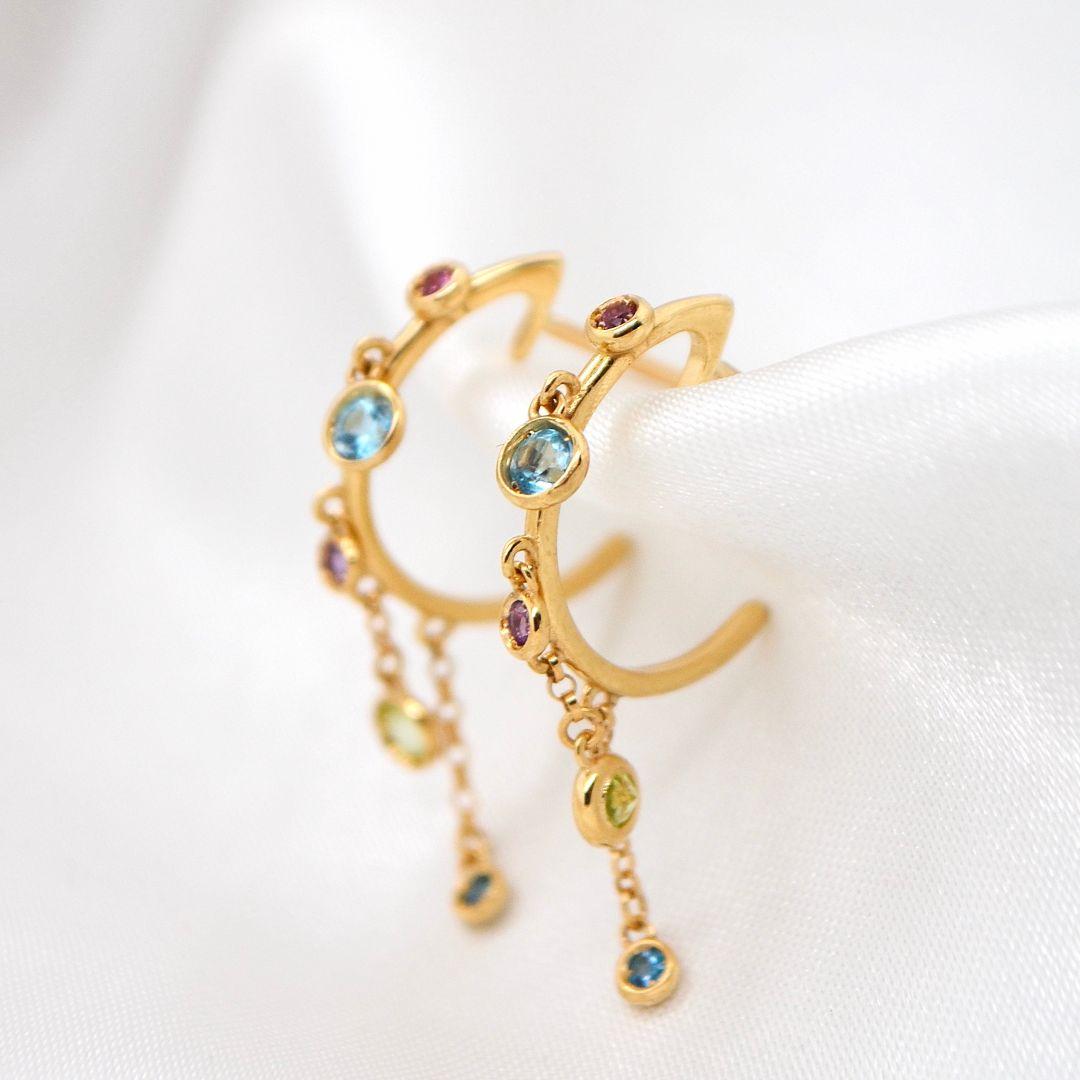Questi straordinari orecchini sono realizzati in oro giallo a 18 carati e presentano una vivace serie di gemme brasiliane. Con le radiose tonalità di Citrino, Peridoto, Topazio Blu, Ametista e Rodolite Rosa, ogni gemma è stata scelta meticolosamente