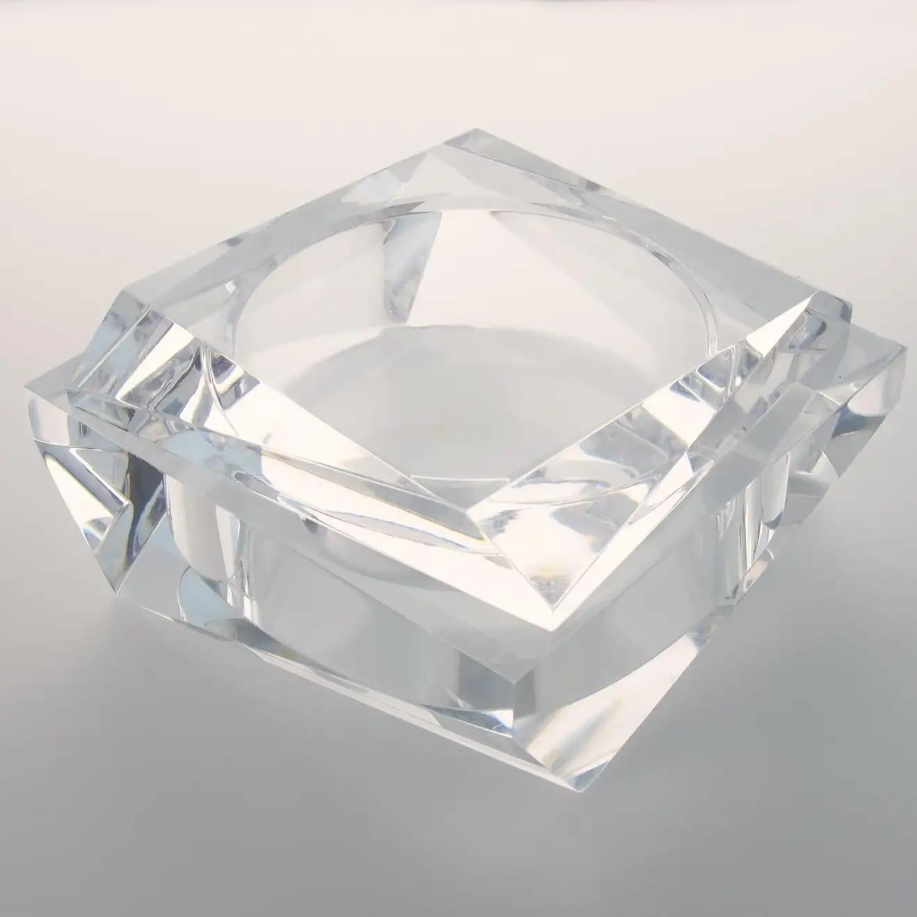 This stunning geometric Lucite decorative trinket-lidded box, made in the 1960s, features a modernist shape with an incredible carved prismatic design. The box is made of crystal clear Lucite with a thick material. It is marked underside: 
