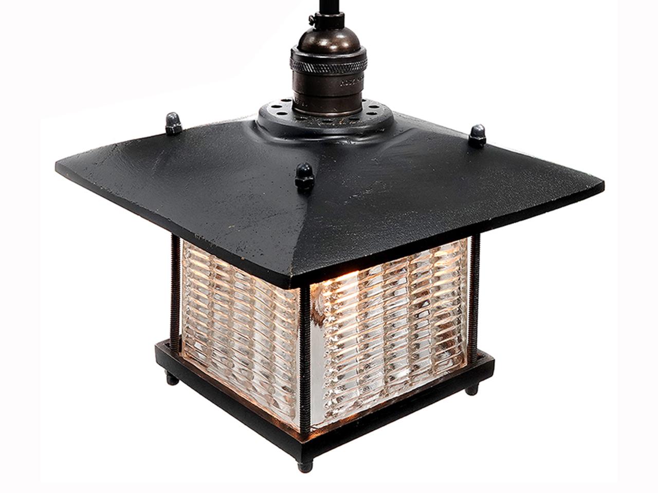 This pendent has a Frank Lloyd Wright feel. The long overhang on the shade has a strong architectural look and goes well with the louvered prismatic glass. The brass is a heavy cast and feels rich. The glass was inspired by early industrial Luxfer