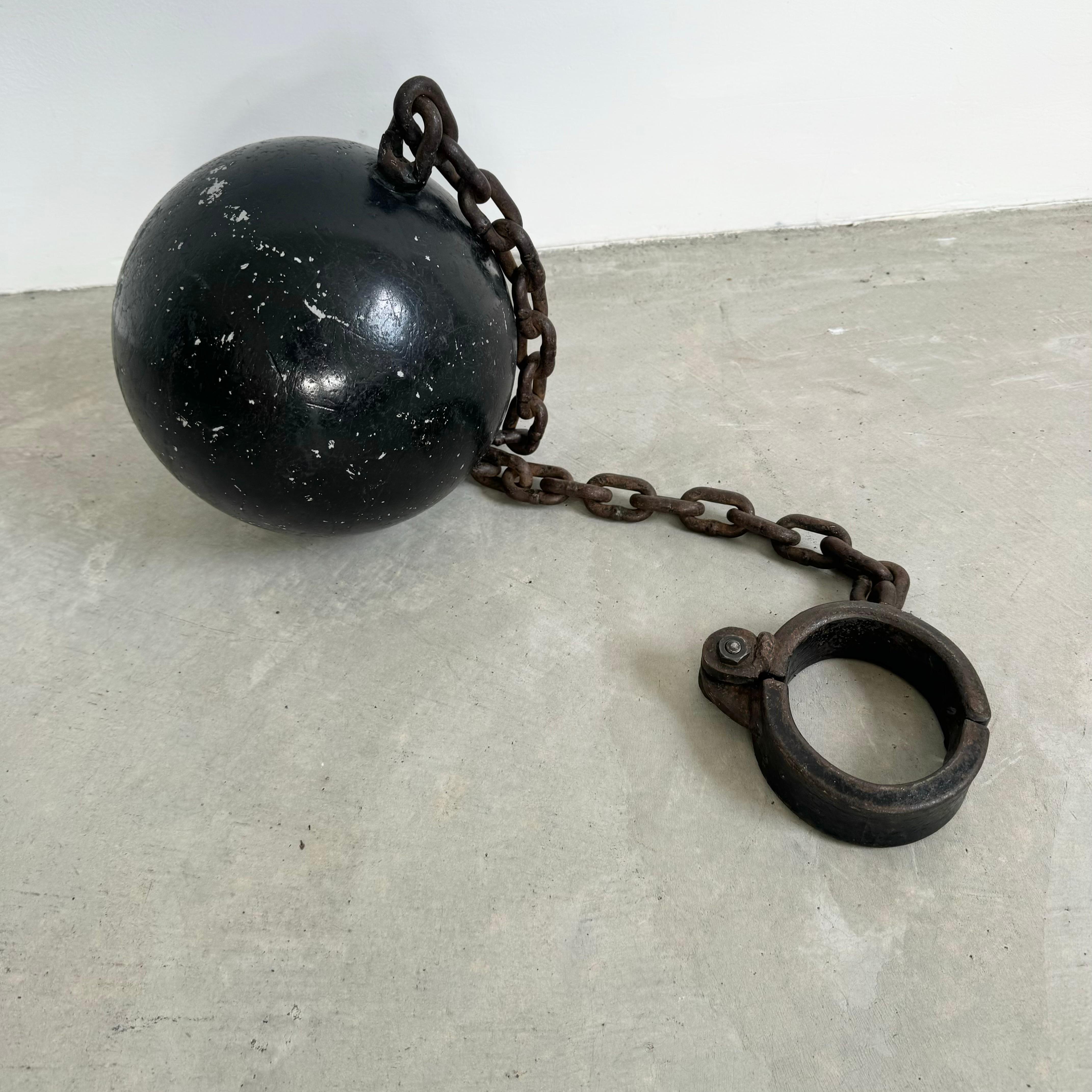 Prison ball and chain shackle. Compelling piece that looks great on a tabletop display, or placed on the ground as a statement. This historical piece of art will add a dark and ominous element to any room. Great conversation starter and powerful