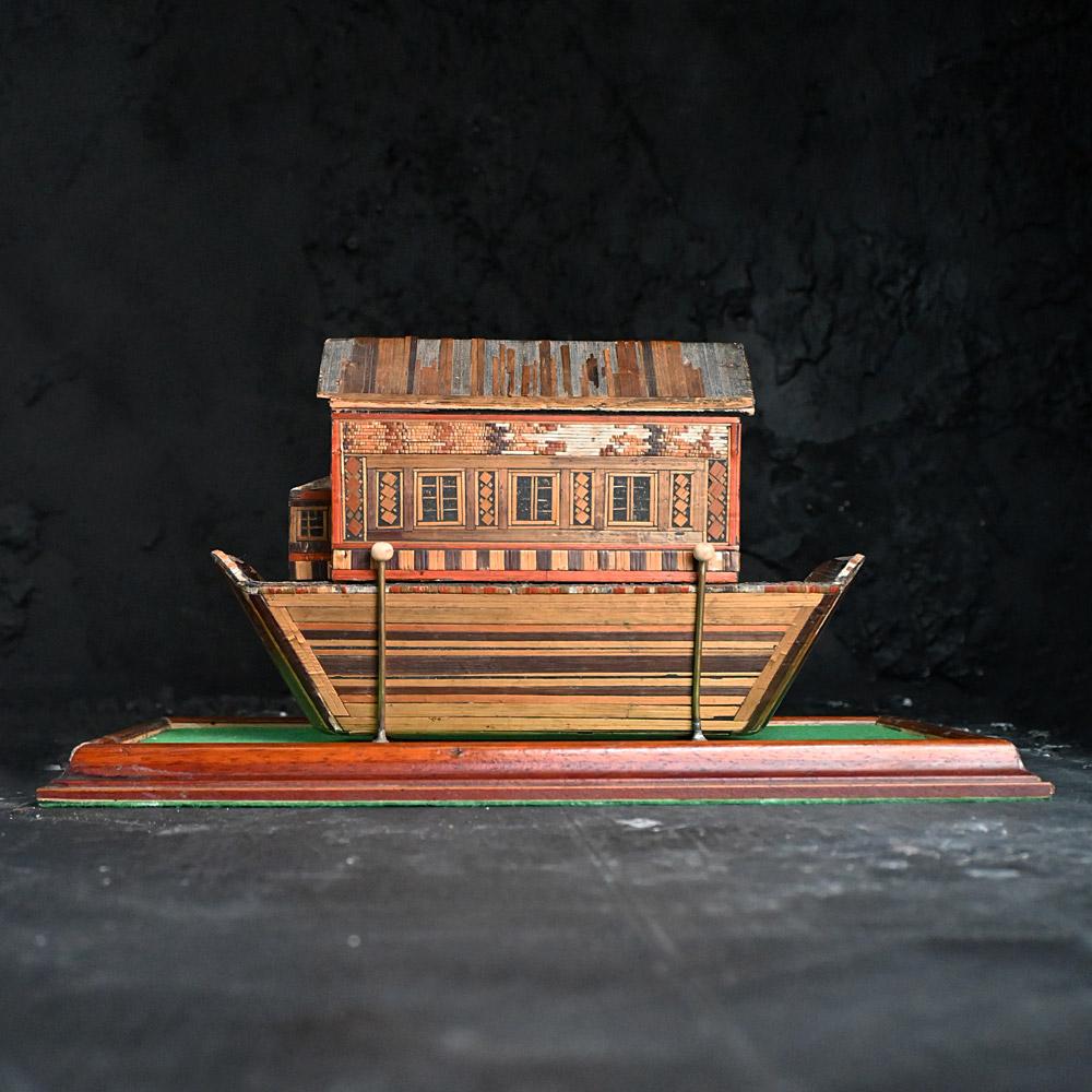 Prisoner of war straw-work ark

Dated from late 18th/early 19th century, the lift-off upper section decorated with doors, windows, and geometric motifs. Covered in wonderful straw work, encased in a bespoke glass diorama with brass supported