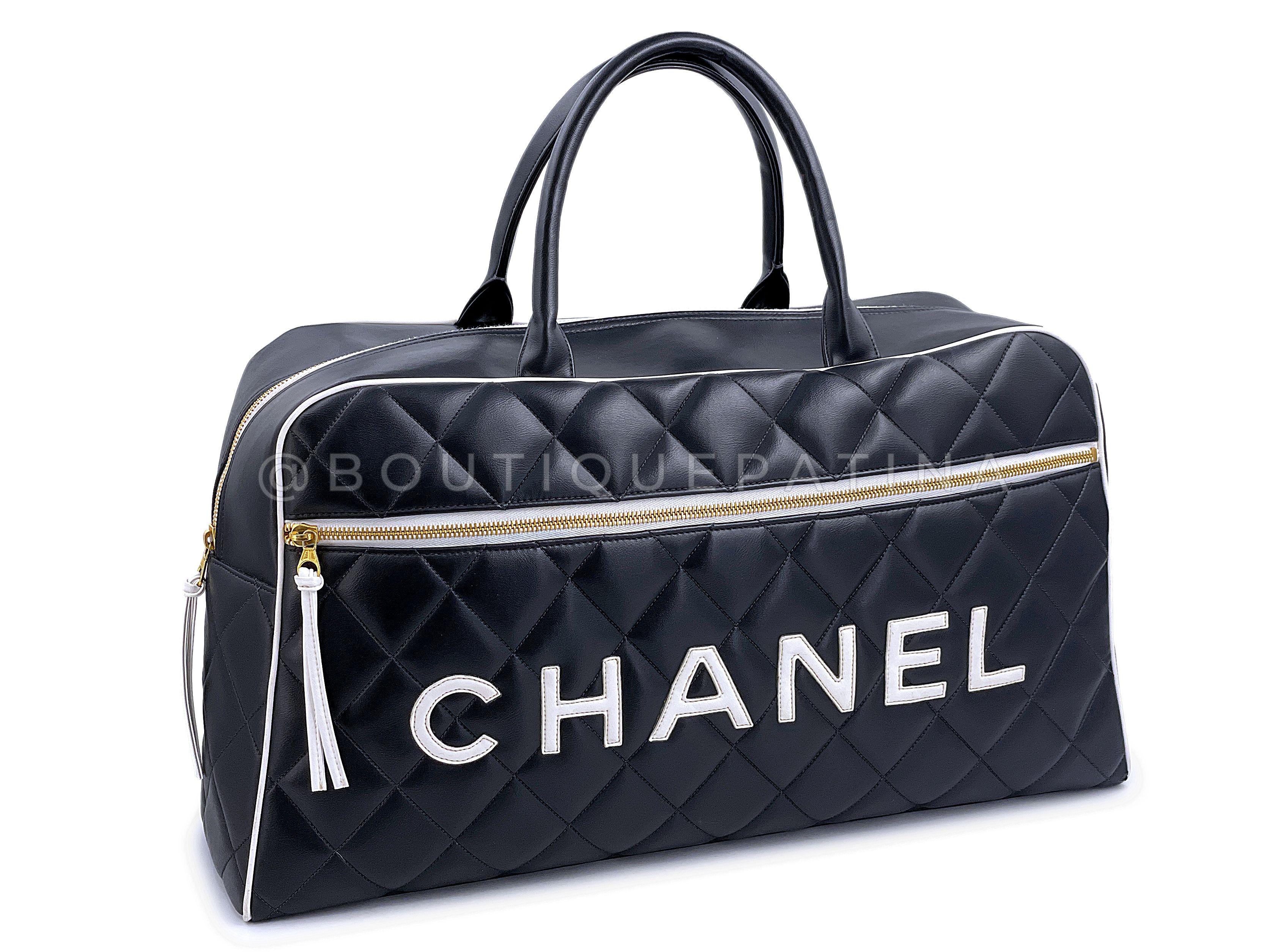 Article du magasin : 67789
Chic et moderne, mais très vintage, ce sac de sport Chanel Letter Logo Large Bowler Duffle Bag de 1995.

Il s'agit d'un grand sac de voyage weekender avec poche extérieure zippée sur le devant, intérieur en cuir noir avec