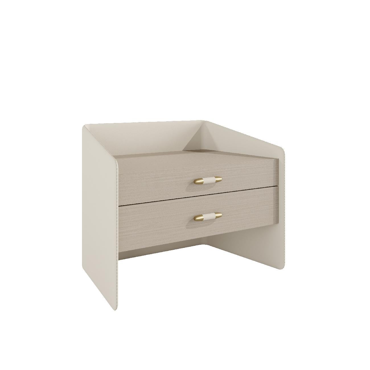Pristine II is a precious object upholstered in leather with meticulous stitching details. 

This bedside table has two drawers, available in wood veneer or lacquered finish. The antique brass handles decorated with leather give the piece a unique