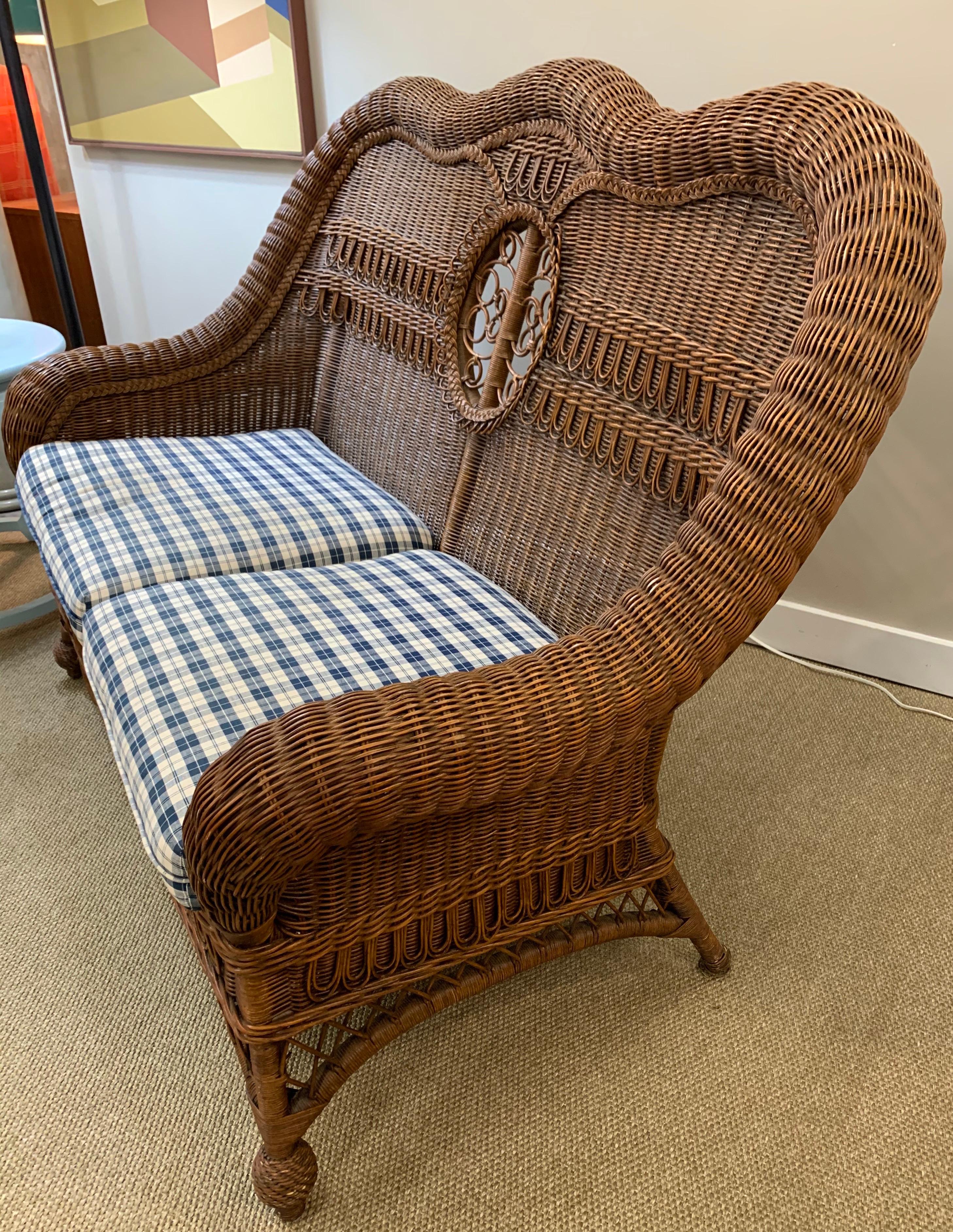 Stunning rich dark brown wicker loveseat with blue and white upholstered cushions.
Intricate wicker weave throughout and, especially at back. All dimensions below.
Great scale and better lines.
