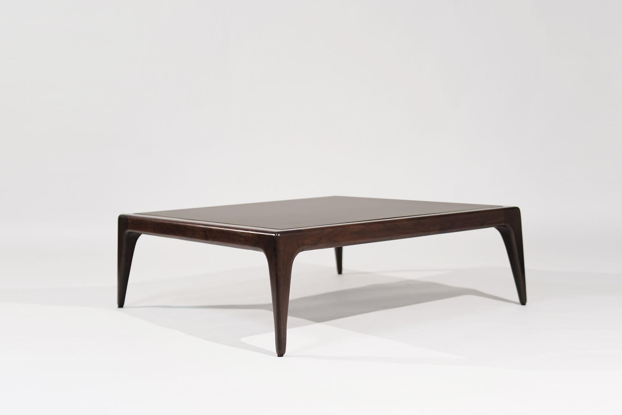 Élevez votre espace de vie avec notre table basse sculpturale, inspirée du style emblématique de Vladimir Kagan. Dotée d'un plateau en bronze laqué, cette pièce unique respire le luxe et la sophistication. Fabriquée à partir de matériaux de haute