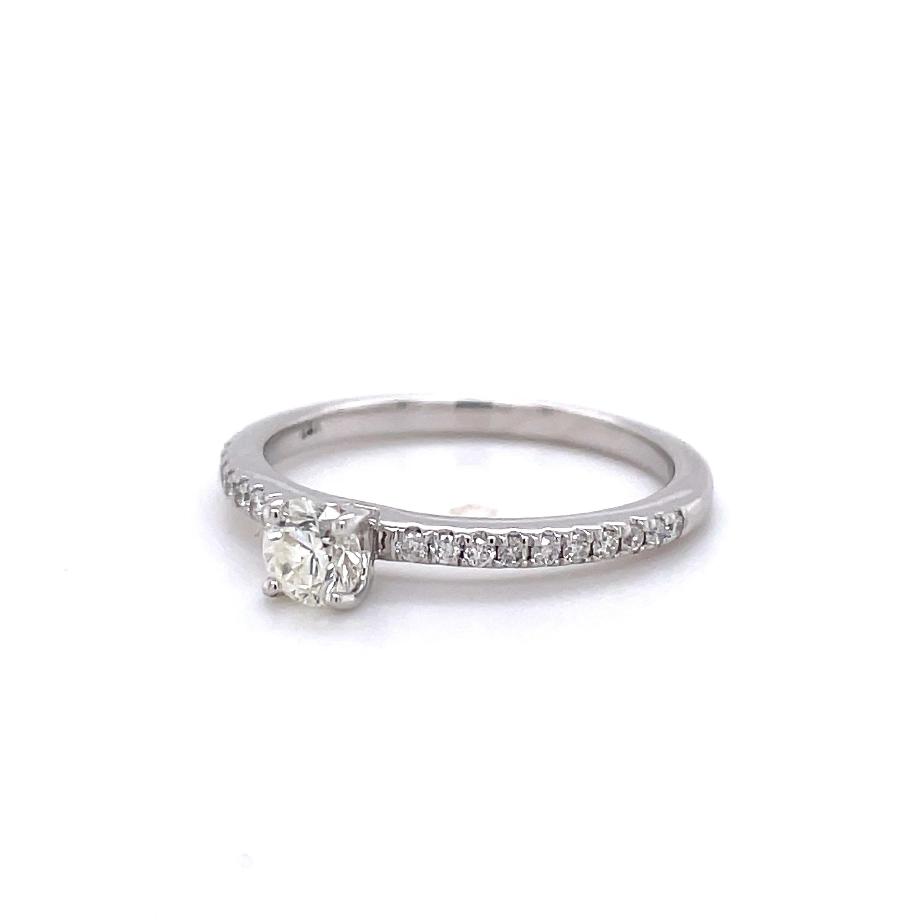 This stunning and elegant diamond ring has a beautiful 0.29 ct (I-J Color, SI2-I1 Clarity) round brilliant diamond in the center with an additional 20 diamonds weighing 0.29 cttw (H-I Color, I1 Clarity) accenting the sides. The ring is crafted in