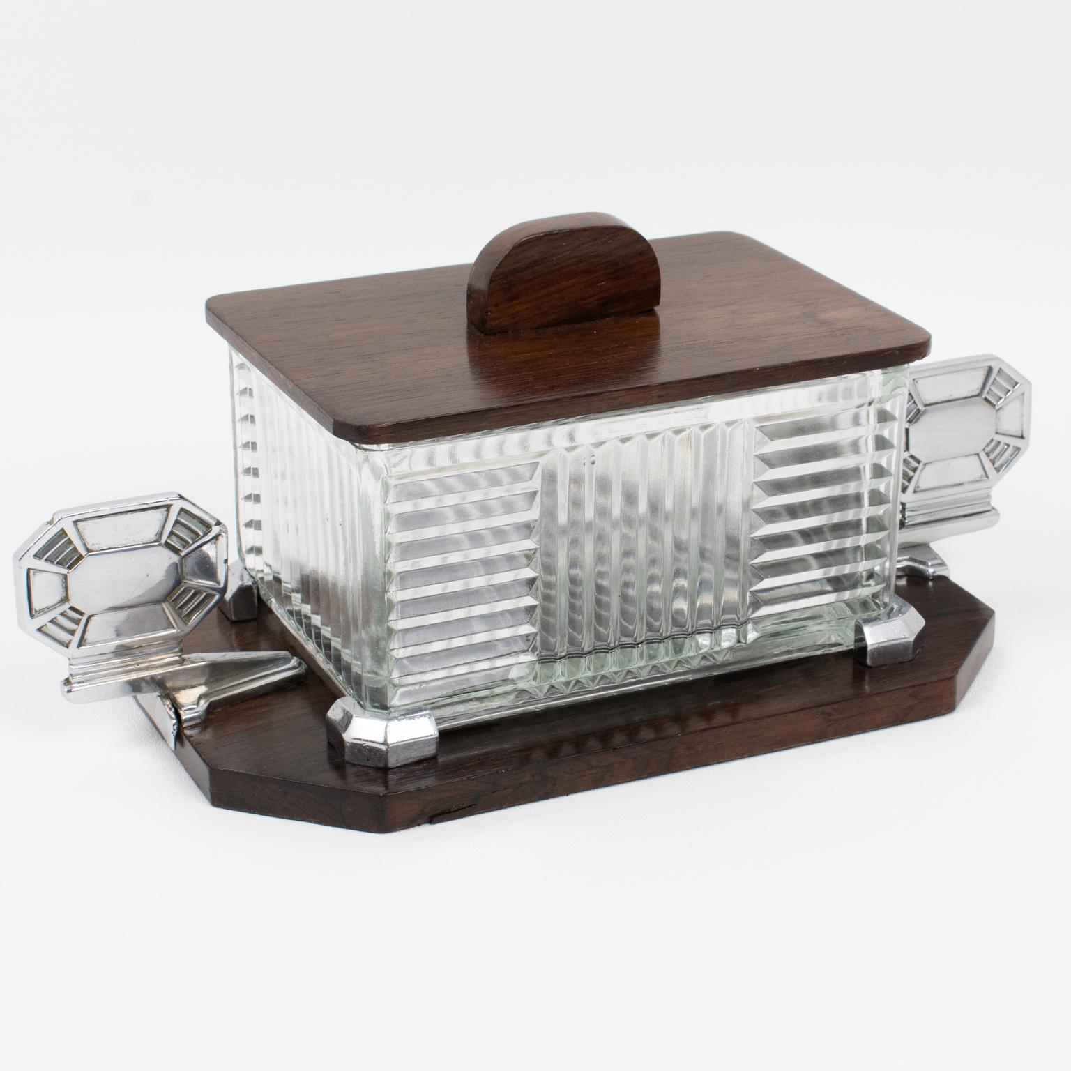 Louis Prodhon, Paris, a conçu et fabriqué cette boîte à biscuits ou bonbonnière décorative Art déco raffinée dans les années 1930. Le design moderniste s'enorgueillit d'une base de support en métal chromé et en bois avec de grandes poignées en