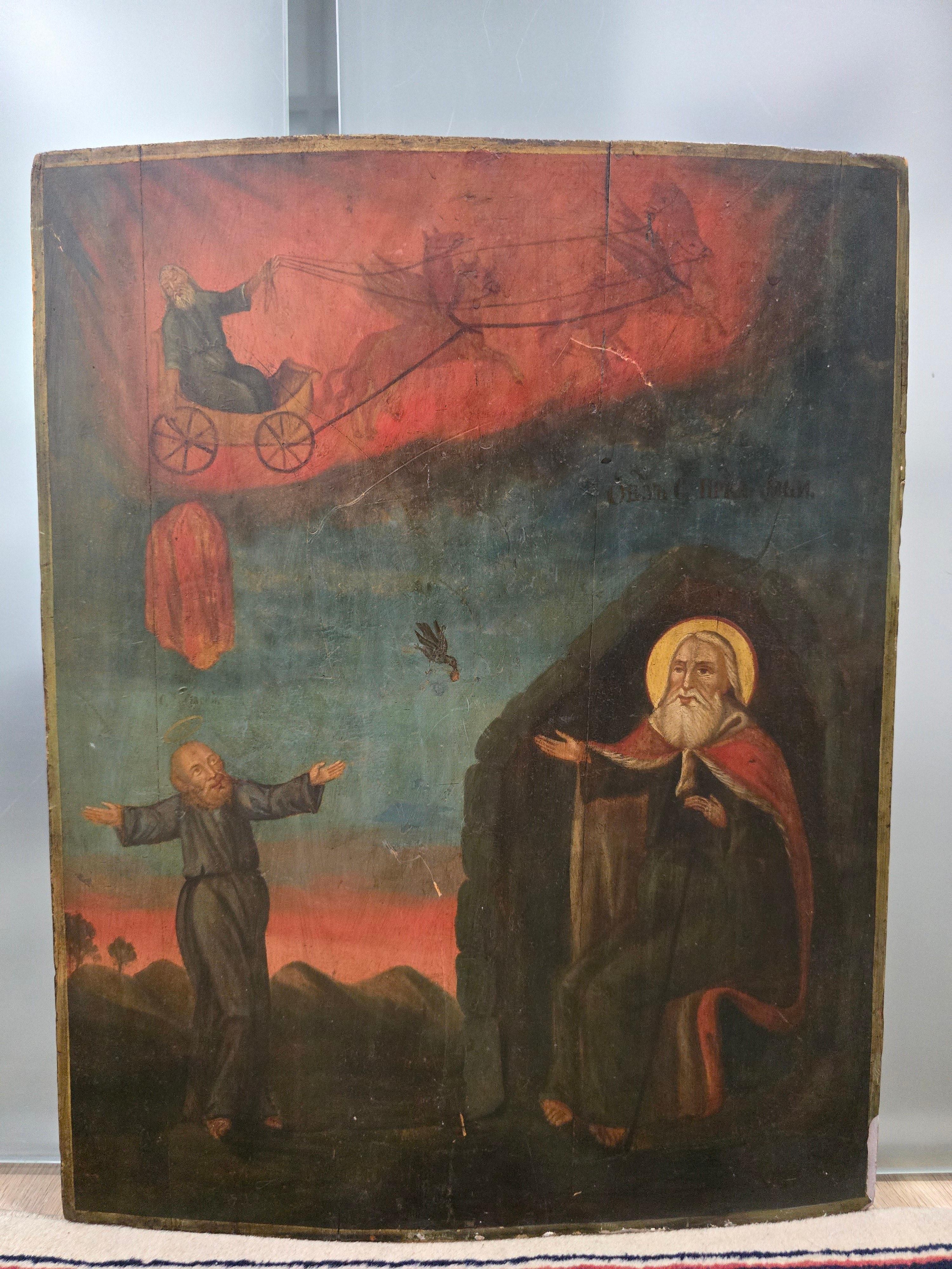 Présentation d'une magnifique icône orthodoxe du XIXe siècle représentant l'ascension du prophète Élie dans une colonne de feu et des scènes de sa vie. Cette pièce est peinte à la détrempe sur un panneau de bois, illustrant l'art religieux