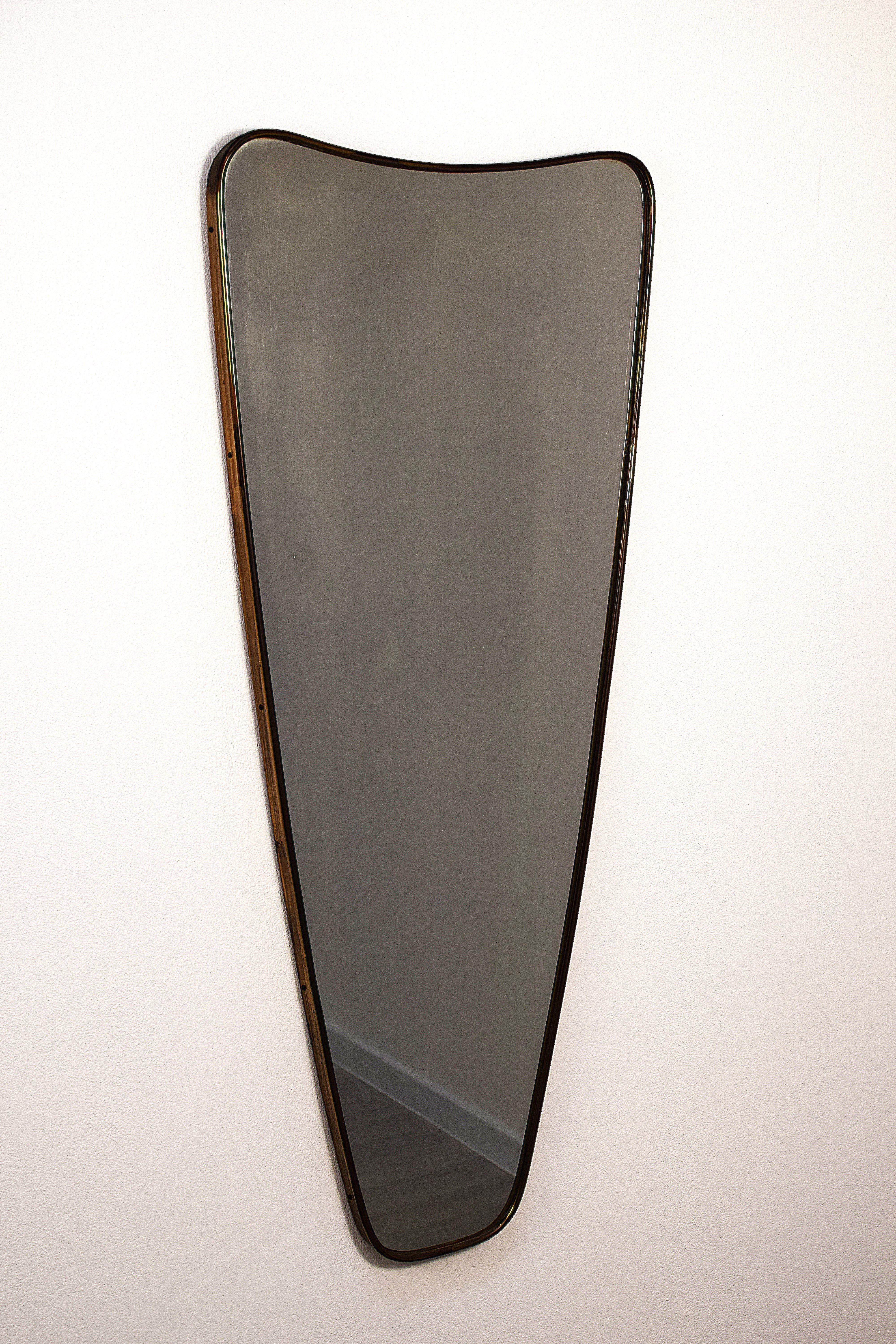 Miroir italien original des années 1950, encadré de laiton, d'un style sobre et élégant typique du design du milieu du siècle. Le cadre est en bois, rehaussé d'une bordure en laiton. Les dimensions totales sont de 94 cm de hauteur, 47 cm de largeur