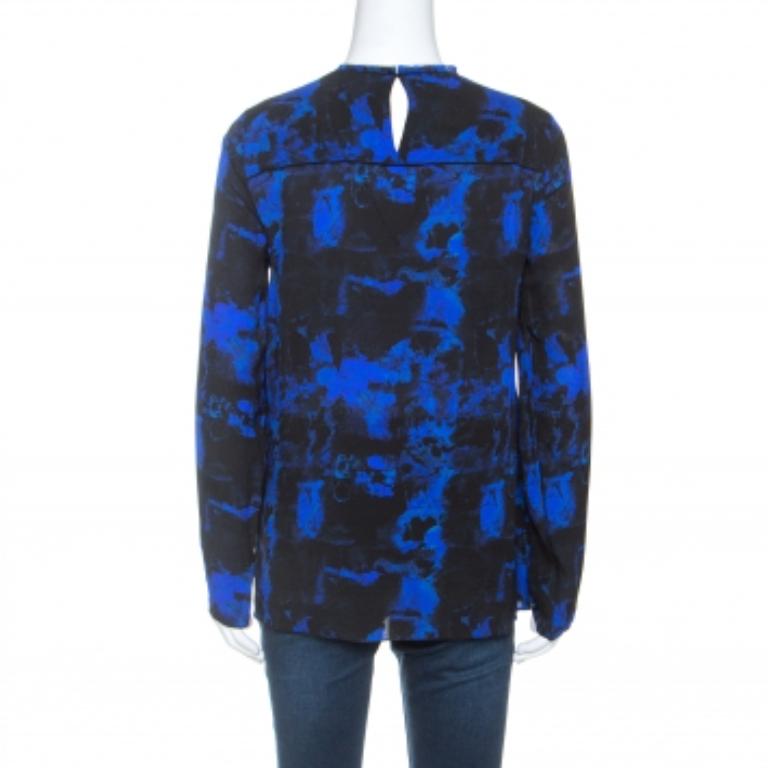 Este top de Proenza Schouler hace hincapié en acertar con los diseños modernos y las tendencias de moda cambiantes. Confeccionado en fina seda, este top atemporal presenta mangas largas, estampados de graffiti y detalle de capas en la parte