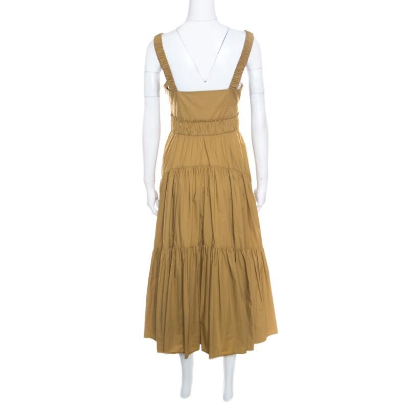 Simple in design and high on style, this Proenza Schuler dress is a must buy! This khaki-green creation is made of 100% cotton and features a gathered tiered silhouette. It flaunts a double shoulder strap detailing on the front and comes equipped