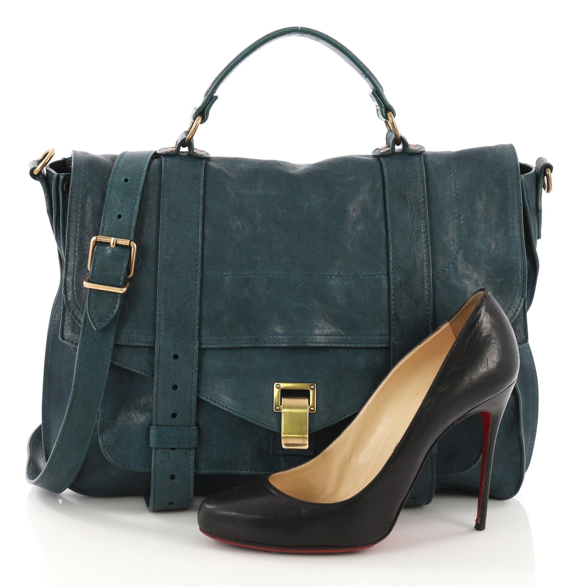 This Proenza Schouler PS1 Satchel Leather Large, crafted in teal leather, features a leather top handle, exterior back zip pocket, and aged gold-tone hardware. Its flip-clasp closure opens to a black fabric interior with a zip pocket. **Note: Shoe