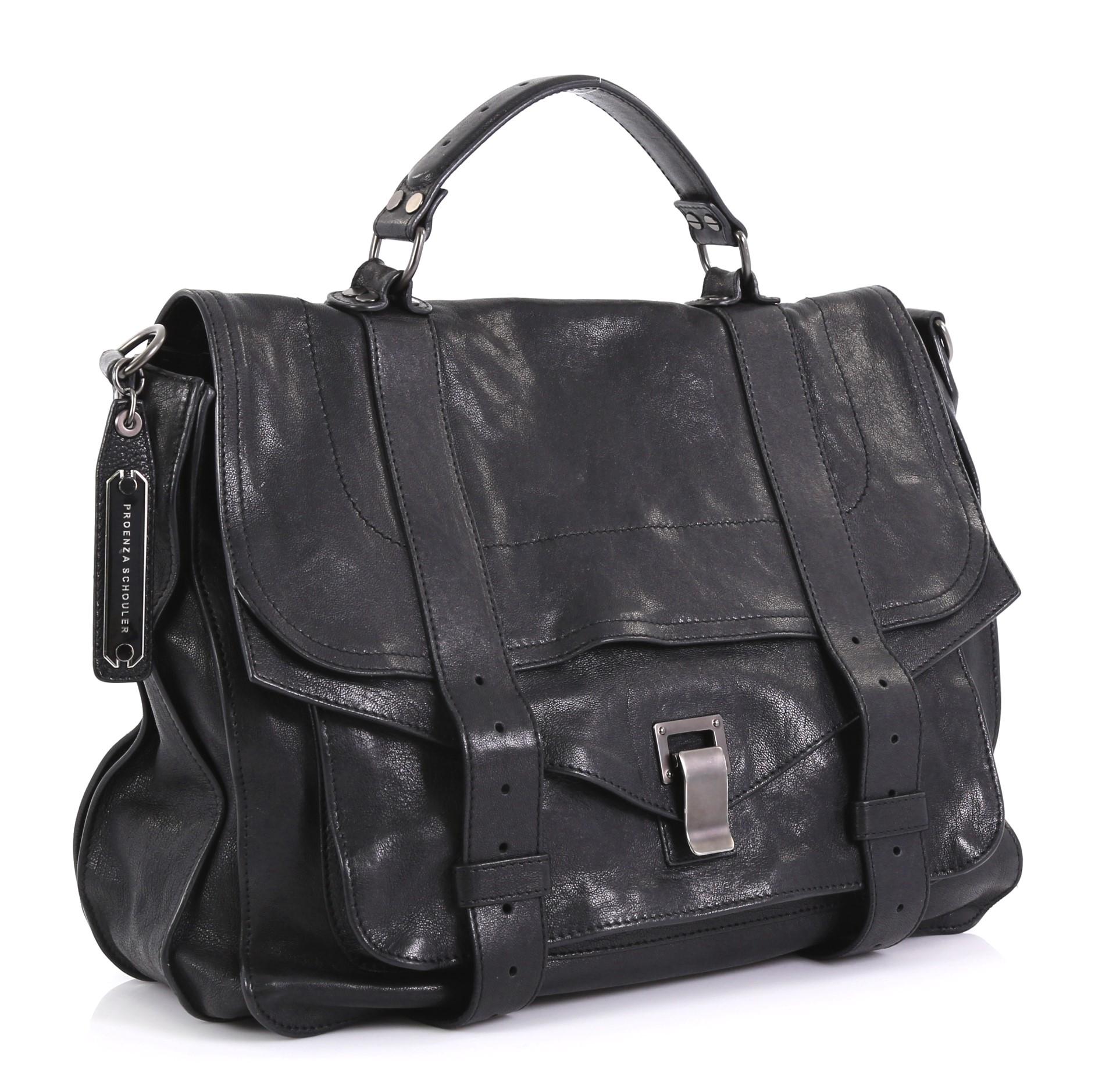 This Proenza Schouler PS1 Satchel Leather Large, crafted in black leather, features a leather top handle, exterior back zip pocket, and matte gunmetal-tone hardware. Its flip-clasp closure opens to a black fabric interior with zip pocket.
