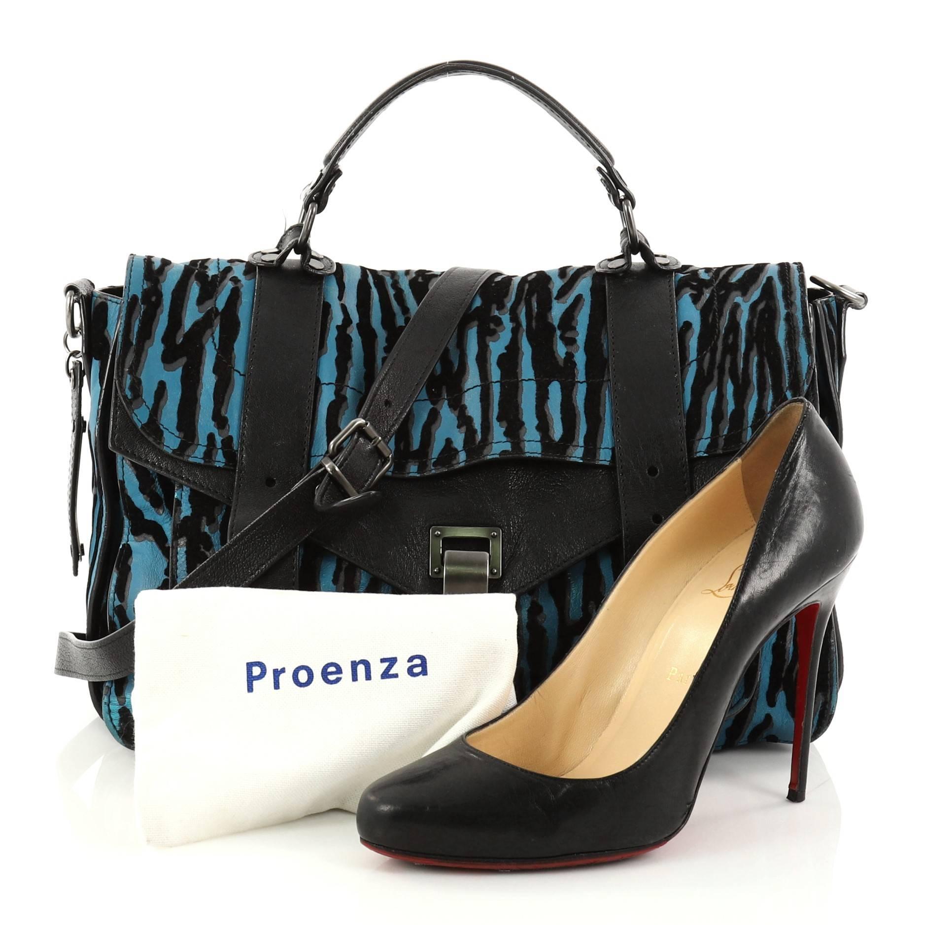 This authentic Proenza Schouler PS1 Satchel Printed Leather Medium is the ideal way to travel with style and functionality. Constructed from black and blue zebra printed leather, this stylish print PS1 satchel is accented with gunmetal-tone