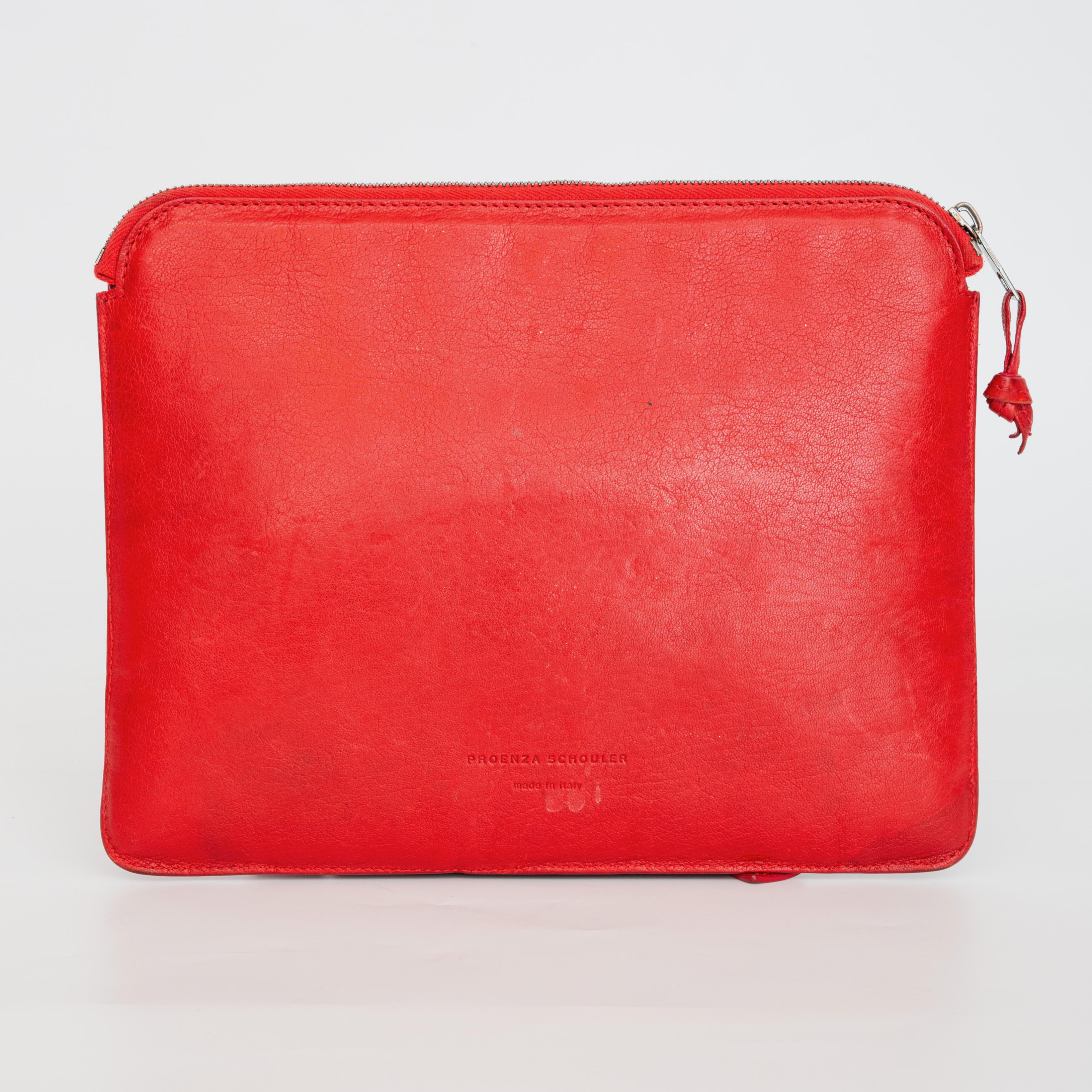 COLOR: Red
MATERIAL: Leather
MEASURES: H 8.5” x L 10.75” x D 0.75” 
COMES WITH: Dust bag
CONDITION: Good - water stains on the bottom and strap, pen mark on the top left. Leather shows signs of wears on corners.