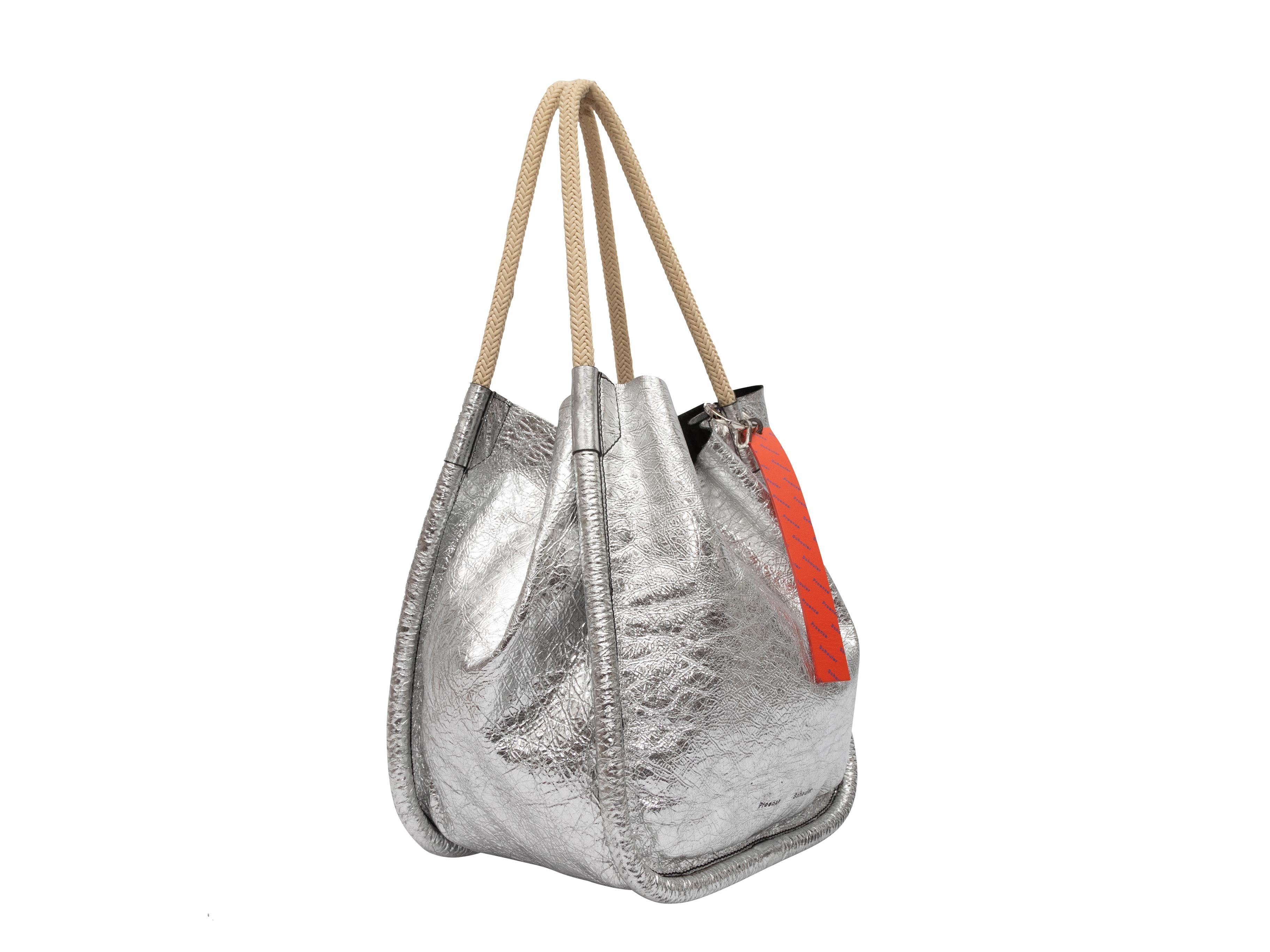 Product Details: Silver Proenza Schouler Metallic Leather Shoulder Bag. This bag features a leather body, silver-tone hardware, and dual woven top handles. 13