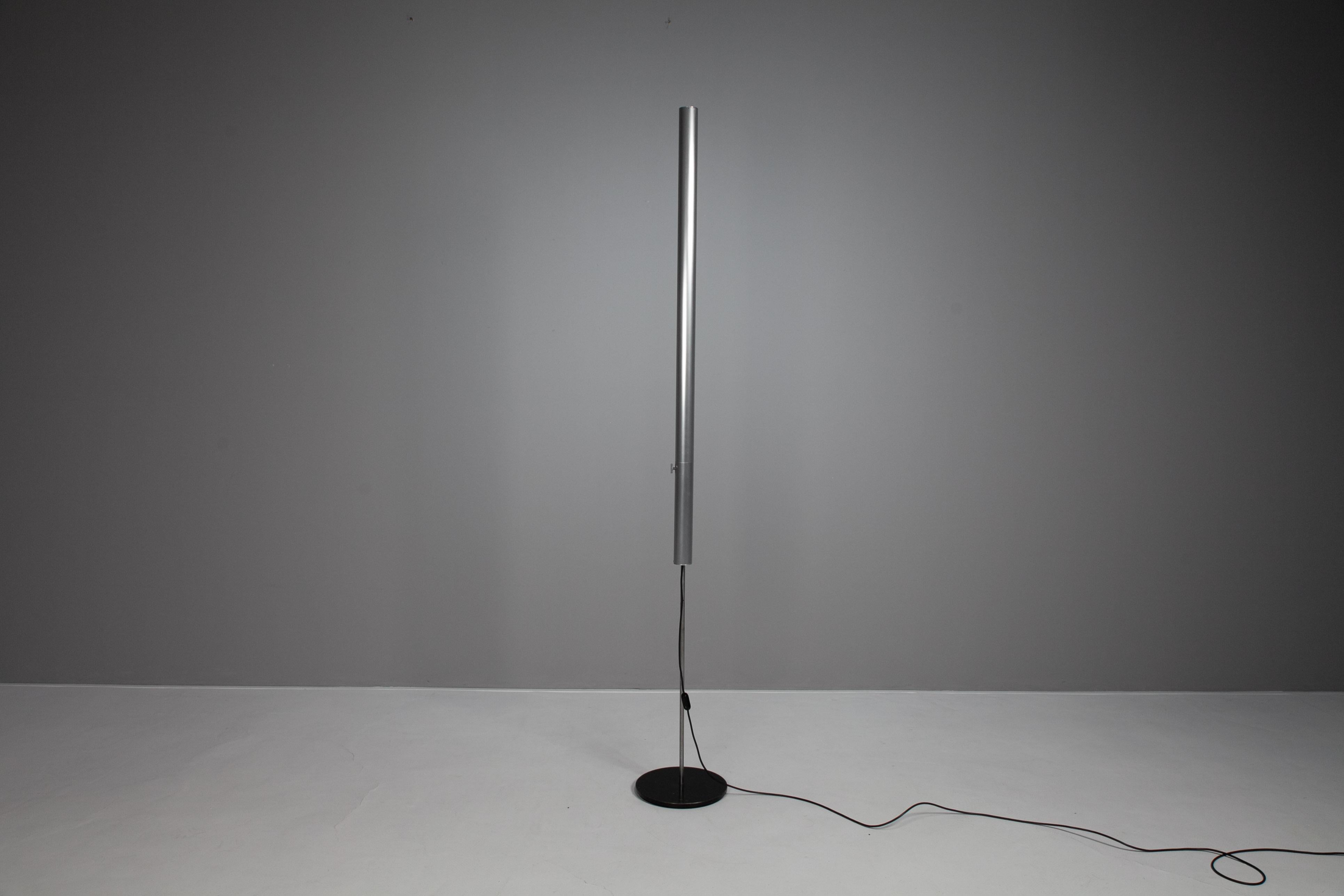 The floor lamp consists of a black painted round steel plate with support rod made of chrome-plated steel tube. Lighting rod made of matt anodized aluminum tube with fluorescent lamp. Joint plexi crystal clear.

The support rod can be unscrewed from