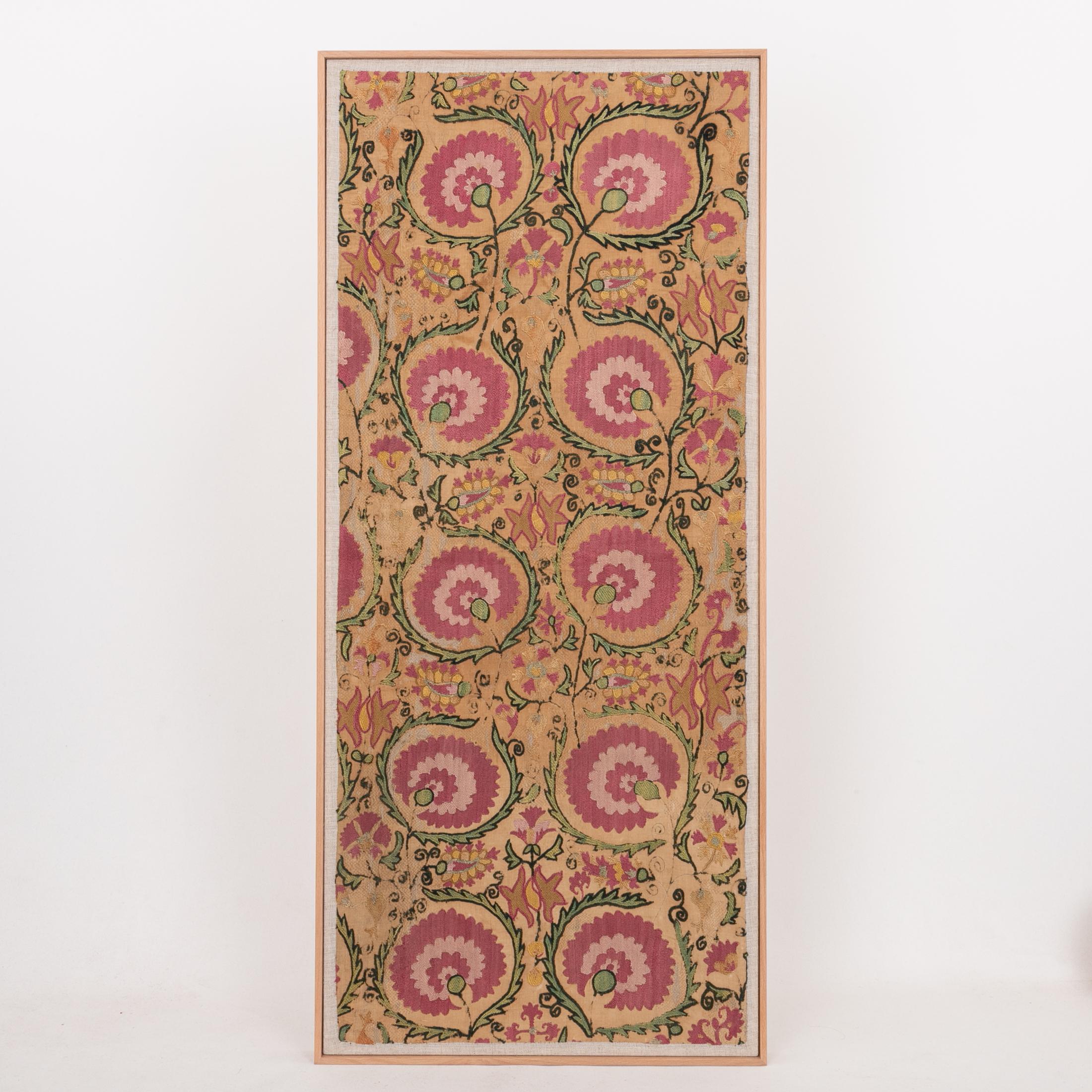 The suzani fragment on the frame is from a 19th C. Suzani. It is hand backed on linen and streched over a strecher and finished with a wooden frame.
Ready to go on any wall.

The item is made from an antique used suzani , therefore it is not in