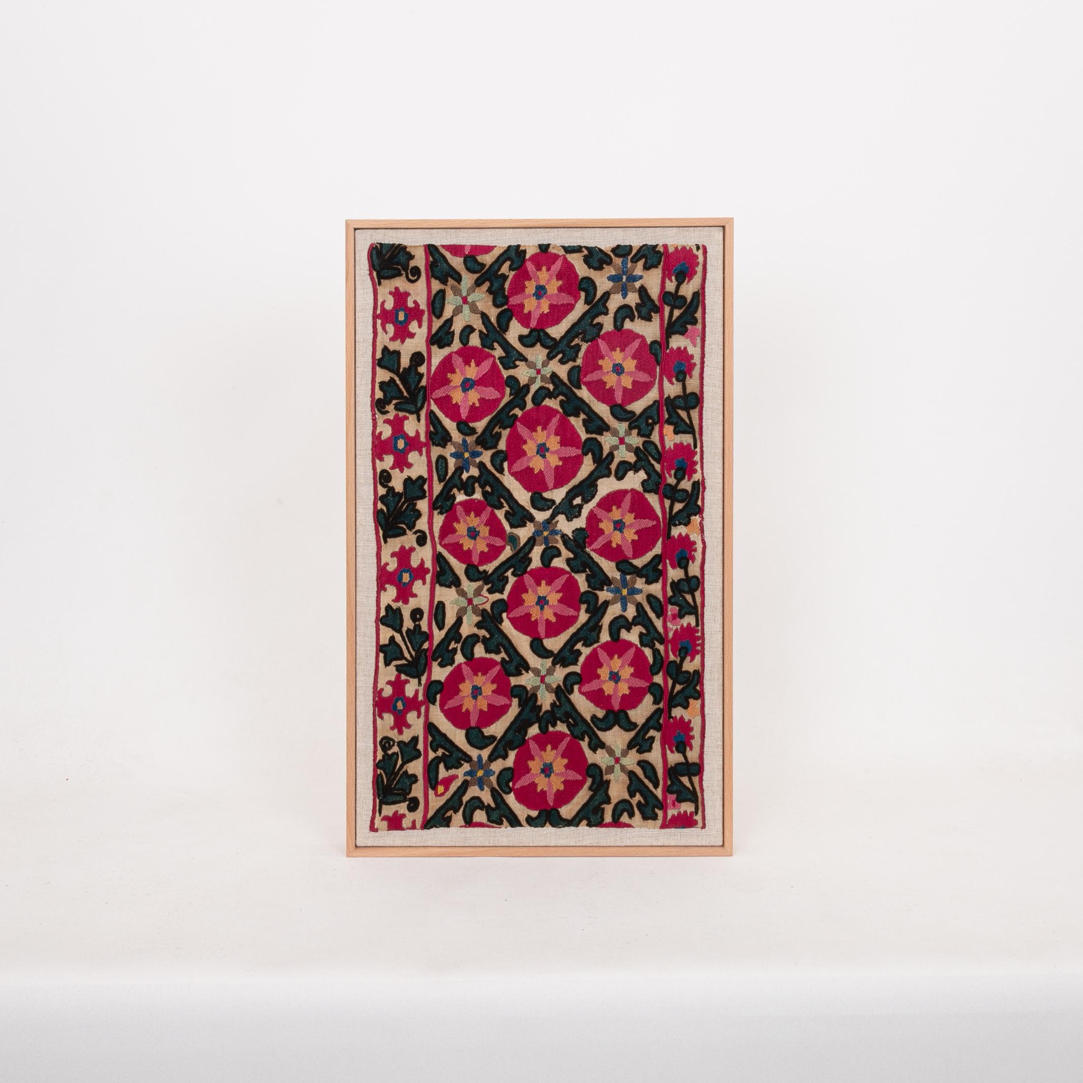 The suzani fragment on the frame is from a 19th C. Suzani. It is hand backed on linen and streched over a strecher and finished with a wooden frame.
Ready to go on any wall.

The item is made from an antique used suzani , therefore it is not in