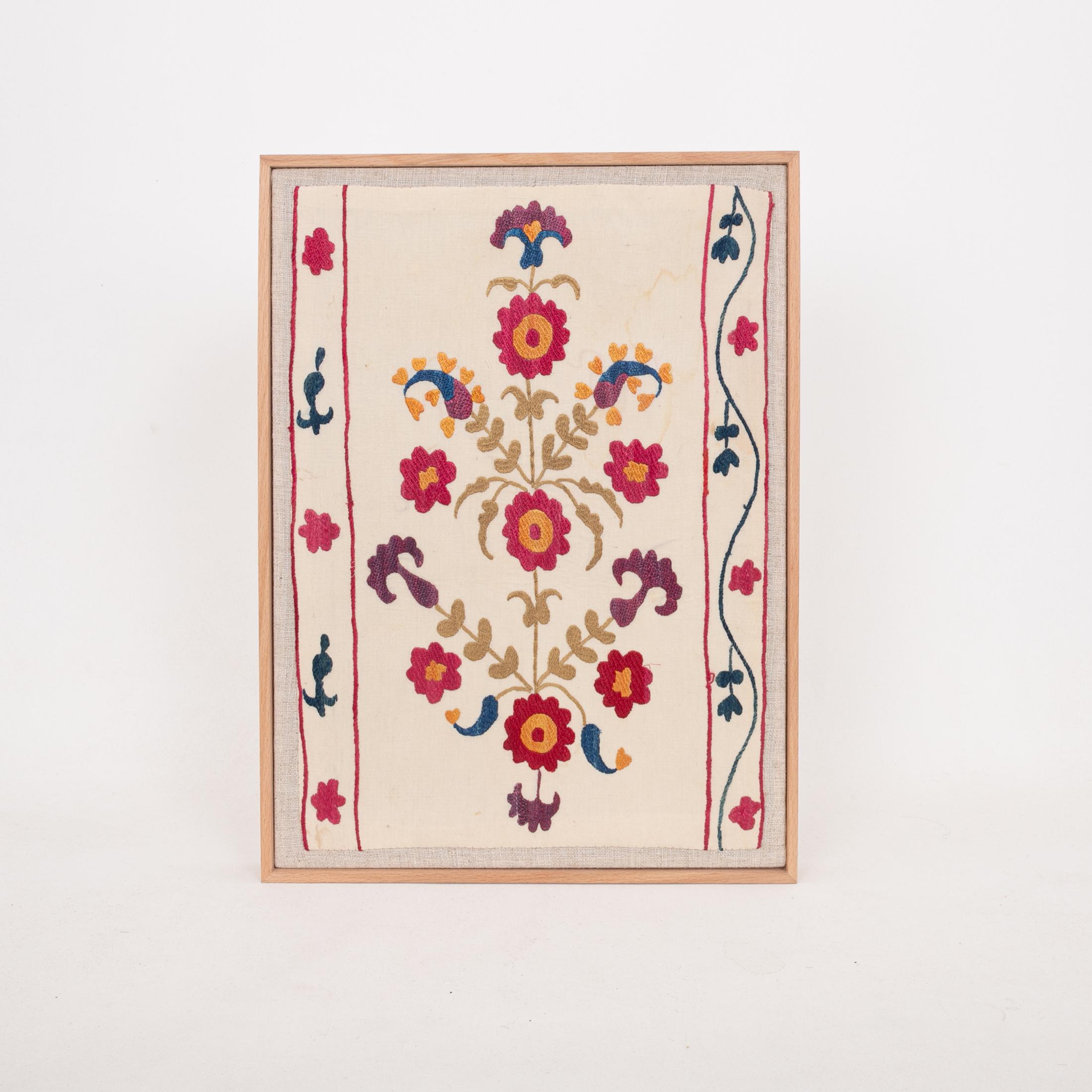 The suzani fragment on the frame is from a 19th C. Suzani. It is hand backed on linen and streched over a strecher and finished with a wooden frame.
Ready to go on any wall.

The item is made from an antique used suzani , therefore it is not in