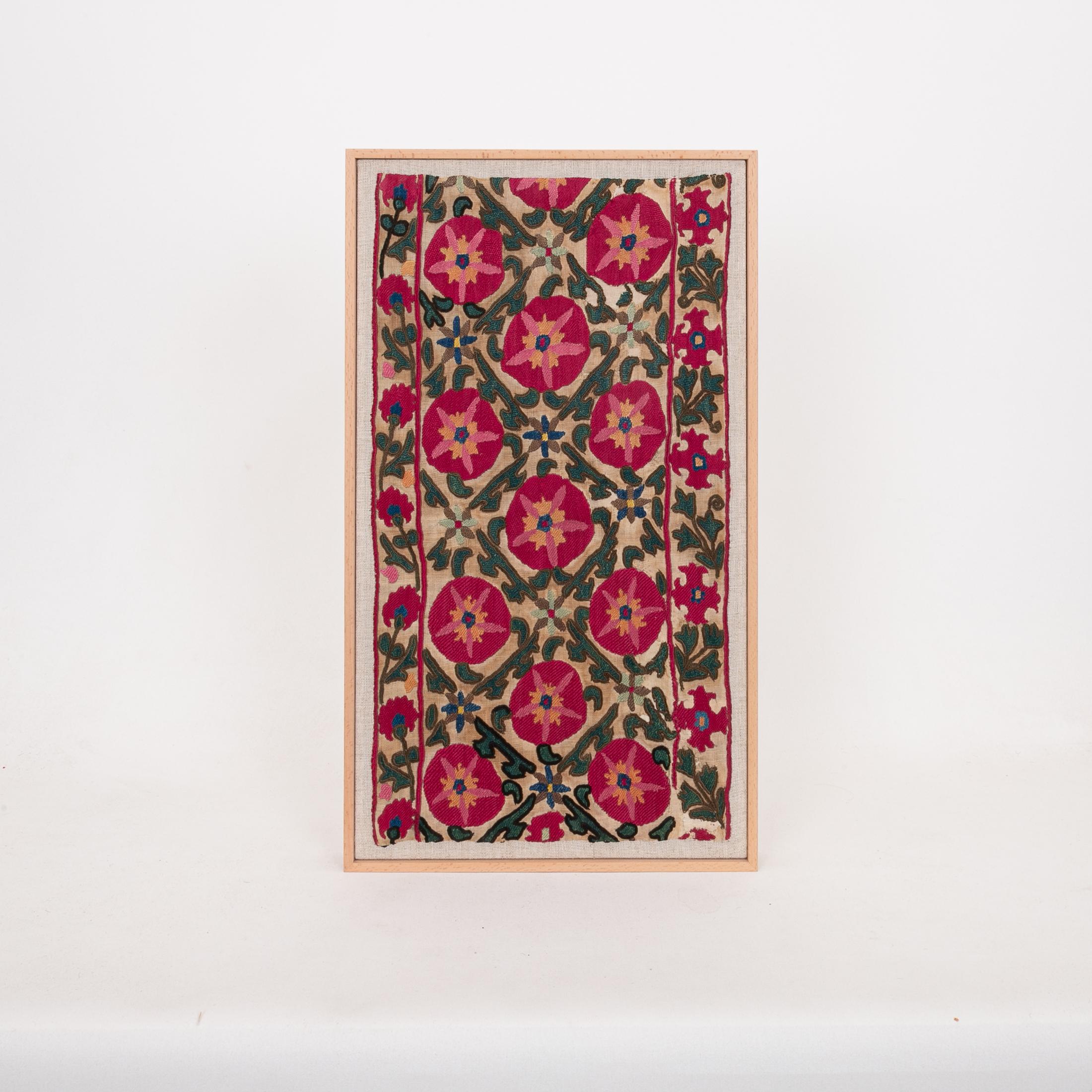 The suzani fragment on the frame is from a 19th C. Suzani. It is hand backed on linen and streched over a strecher and finished with a wooden frame.
Ready to go on any wall.

The item is made from an antique used suzani , therefore it is not in