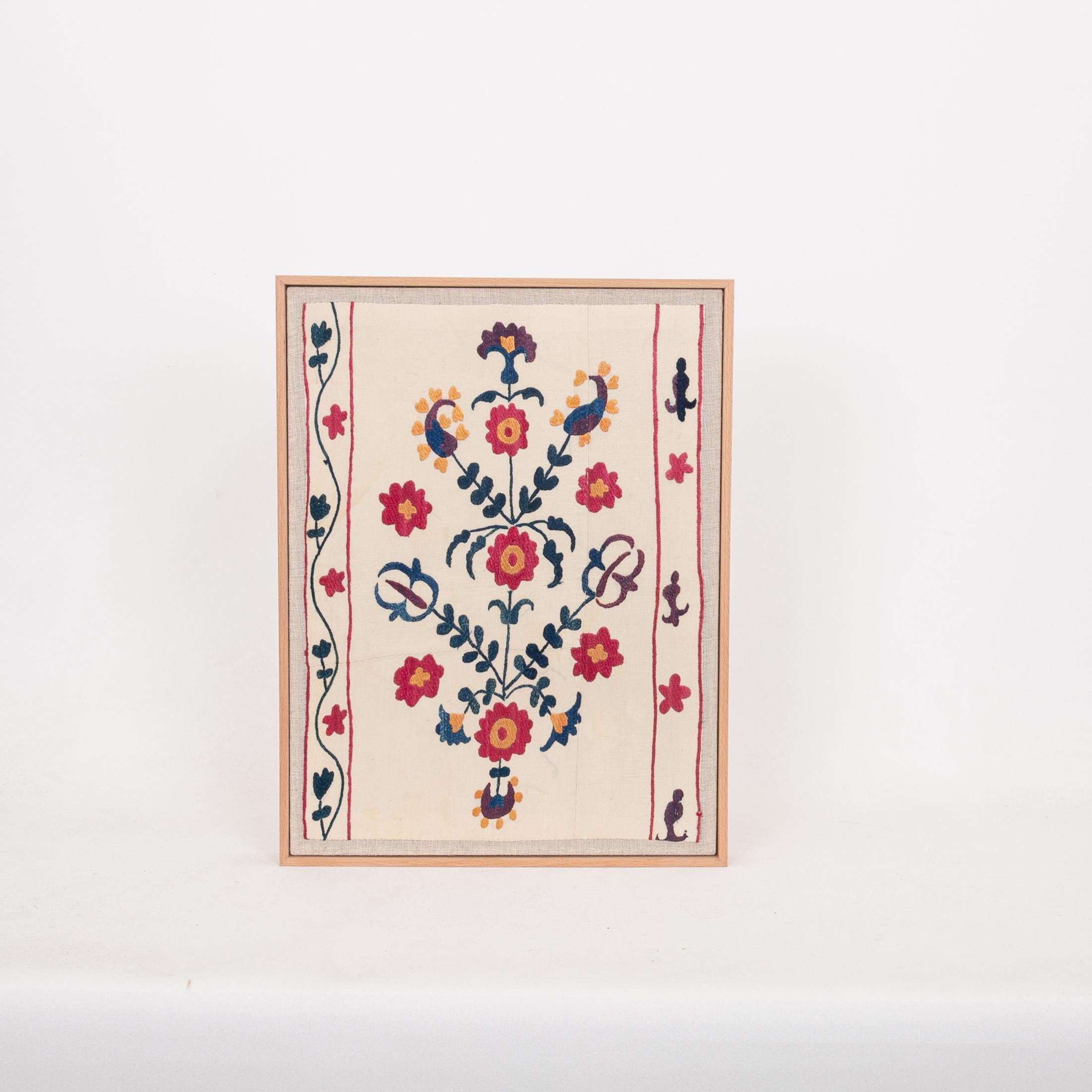 The suzani fragment on the frame is from a 19th C. Suzani. It is hand backed on linen and streched over a strecher and finished with a wooden frame.
Ready to go on any wall.

The item is made from an antique used suzani , therefore it is not in