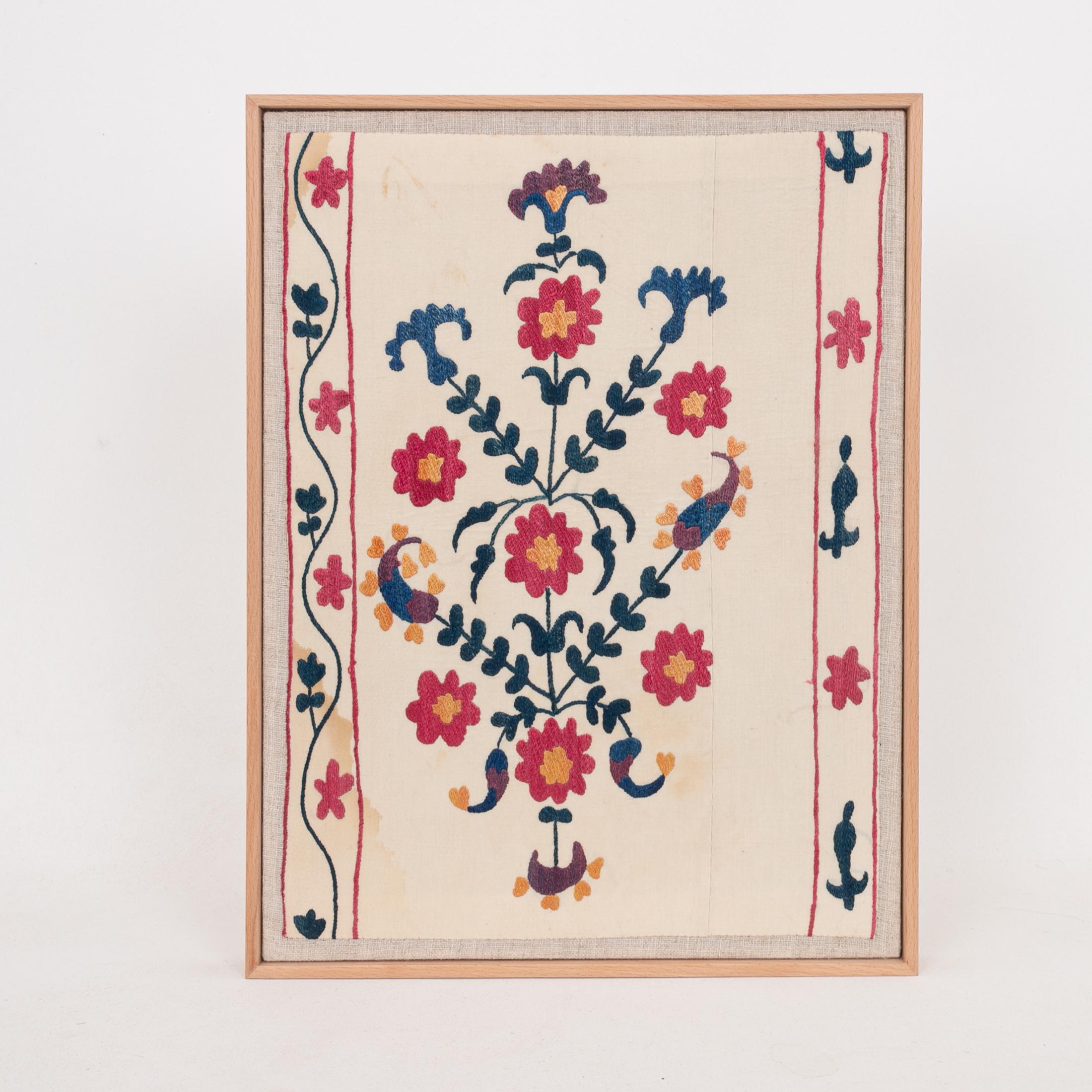 The suzani fragment on the frame is from a 19th C. Suzani. It is hand backed on linen and streched over a strecher and finished with a wooden frame.
Ready to go on any wall.

The item is made from an antique used suzani , therefore it is not in