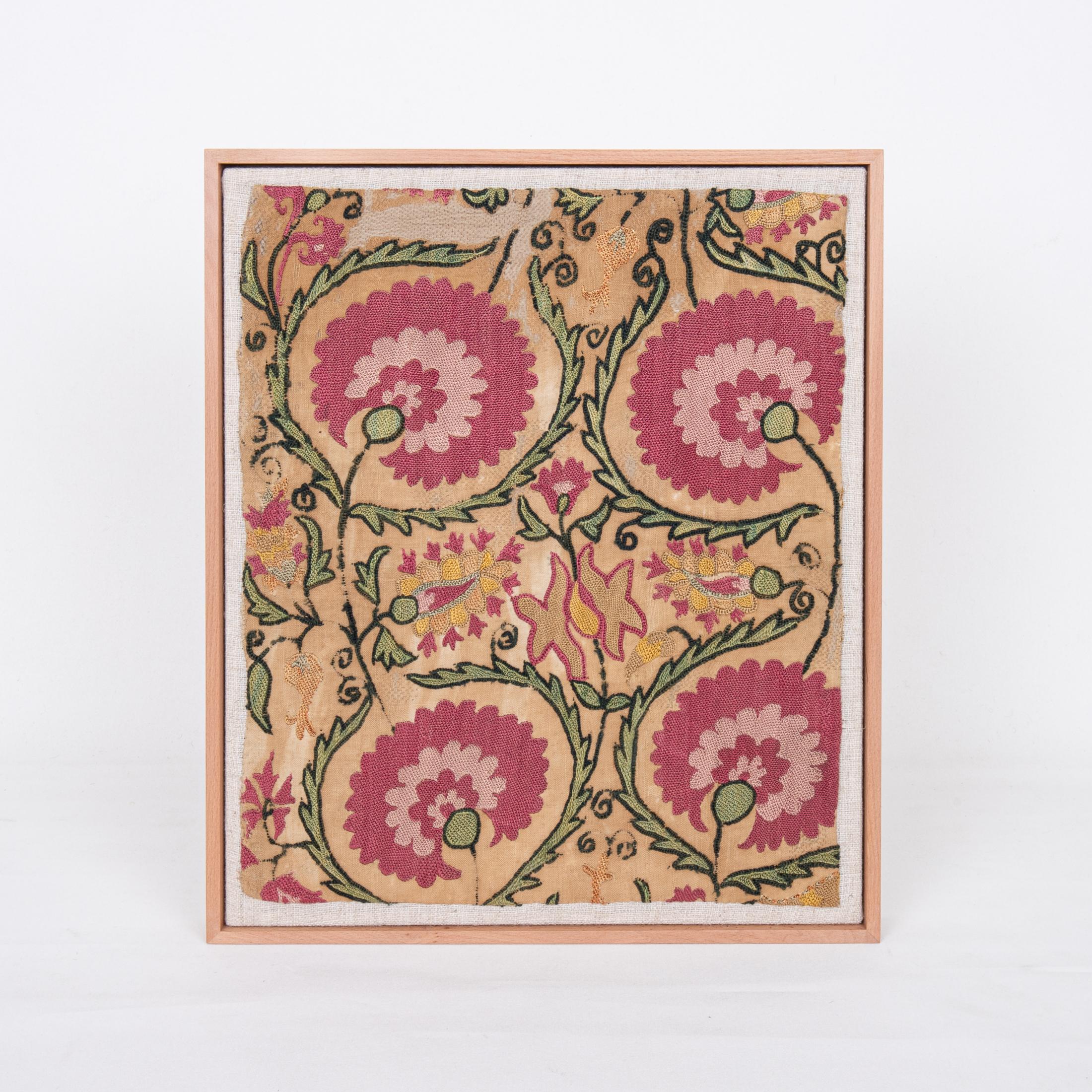 The suzani fragment on the frame is from a 19th C. Suzani. It is hand backed on linen and streched over a strecher and finish with a wooden frame.
Ready to go on any wall.

The item is made from an antique used suzani , therefore it is not in brand