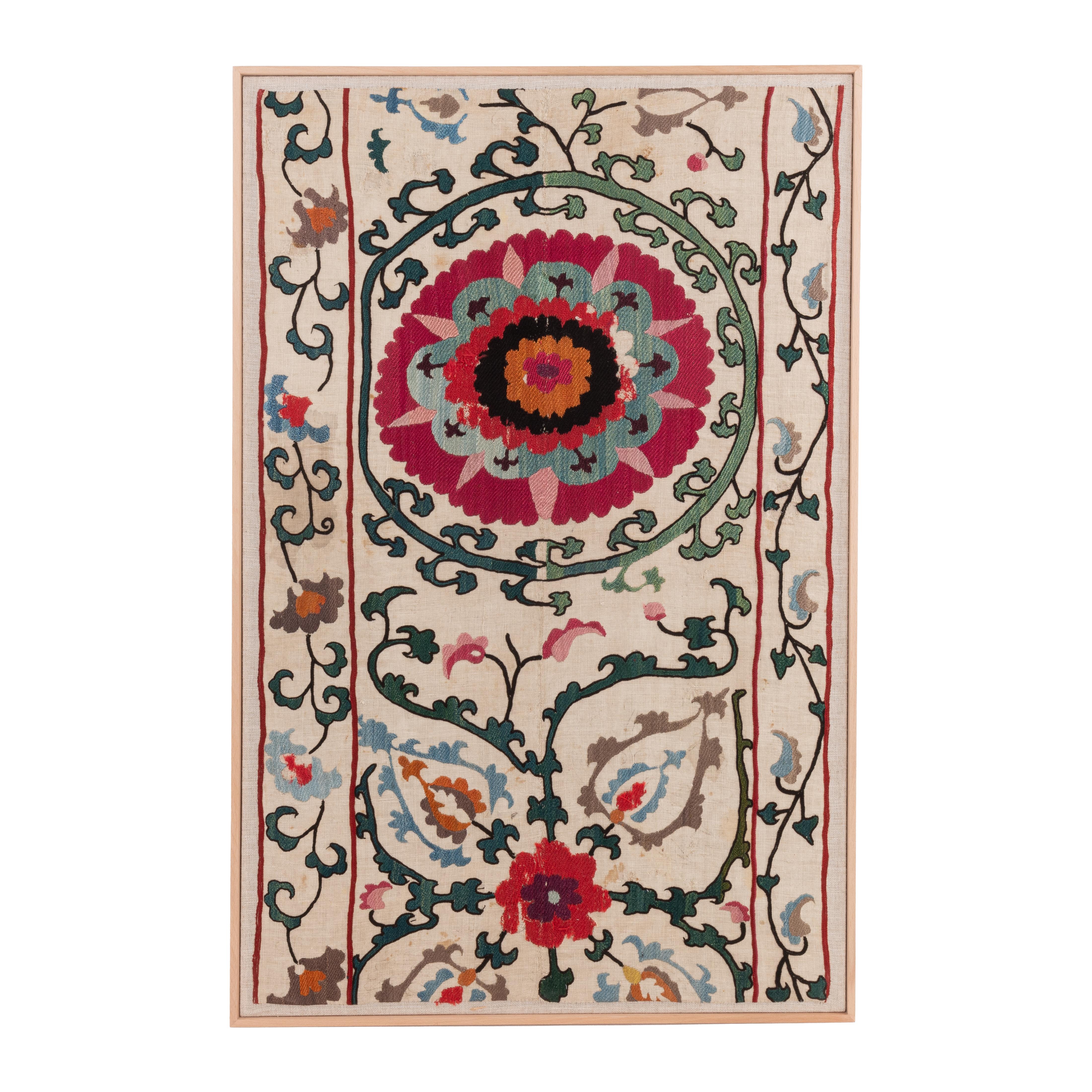 The suzani fragment on the frame is from a 19th C. Suzani. It is hand backed on linen and stretched over a stretcher and finished with a wooden frame.
Ready to go on any wall.

The item is made from an antique used suzani , therefore it is not in