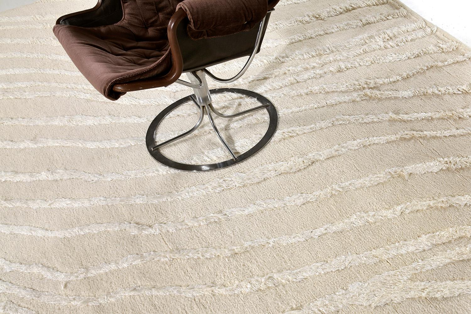 The deeply contrasting and luxurious wool rug with silk embossed detailing features prominently in the beauty of 'Profile'. The surface is ever changing. A brushing turns the direction of the fibers. The silk pile is lustrous, refracting light in