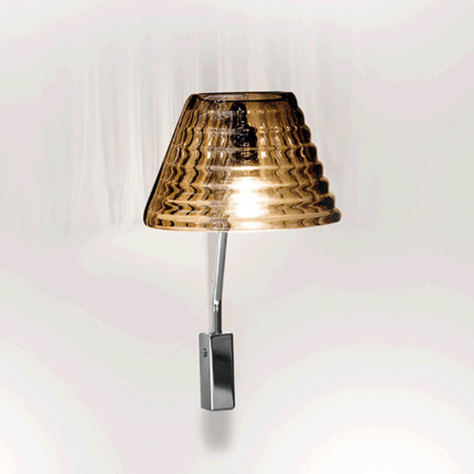 Lampada da parete Profili PROAPM di Mazzega 1946
Dimensioni: L 22 x P 25 x H 38 cm.
Materiali: Telaio: Cromo lucido. 
Diffusore: Cristallo trasparente.
Peso: 003 Kg.

Le radici di Mazzega1946 affondano a Murano, terra di maestri vetrai che ancora
