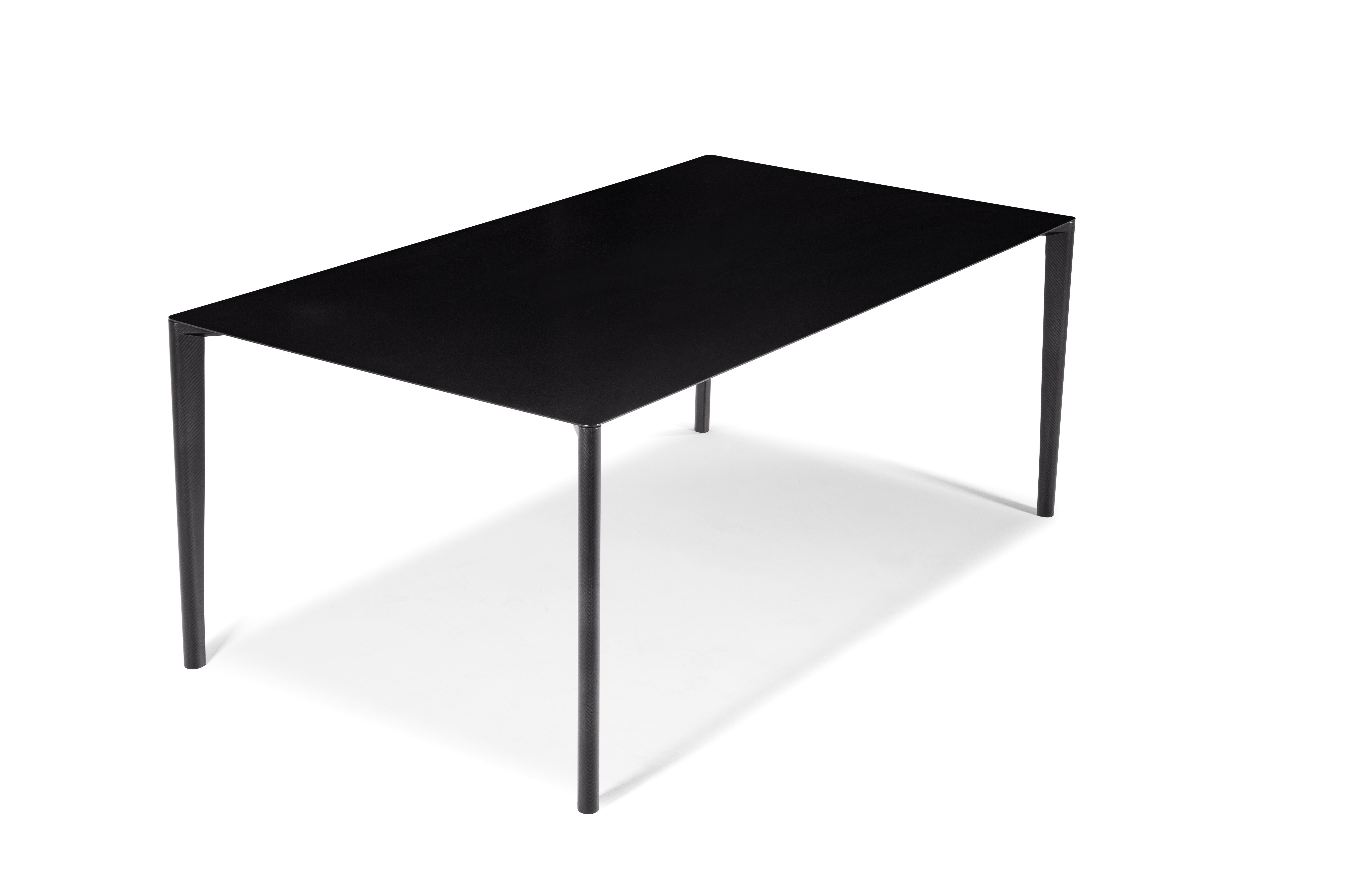 Profilo table is a modern, essential, linear design table which combines a light shape with the strength and resistance of carbon fiber.
This rectangular table is both functionally and aesthetically characterized by the predominance of carbon