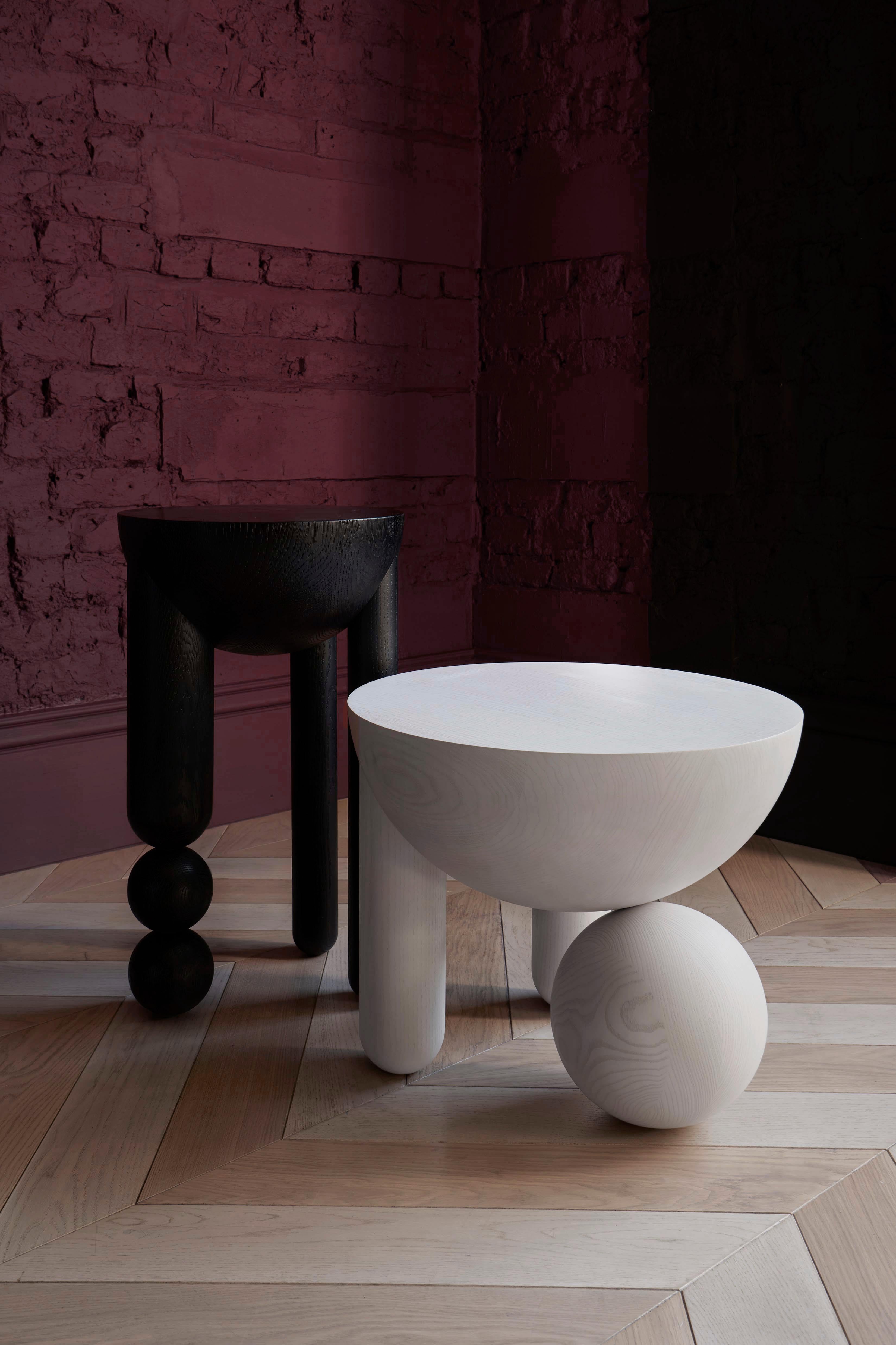 Profiterole small coffee table and Profiterole occasional table are in marble and wood respectively, supported by round dessert-like spheres and semi-cupped legs which support a rounded top. The coffee table comes in nero marquina or white carrara