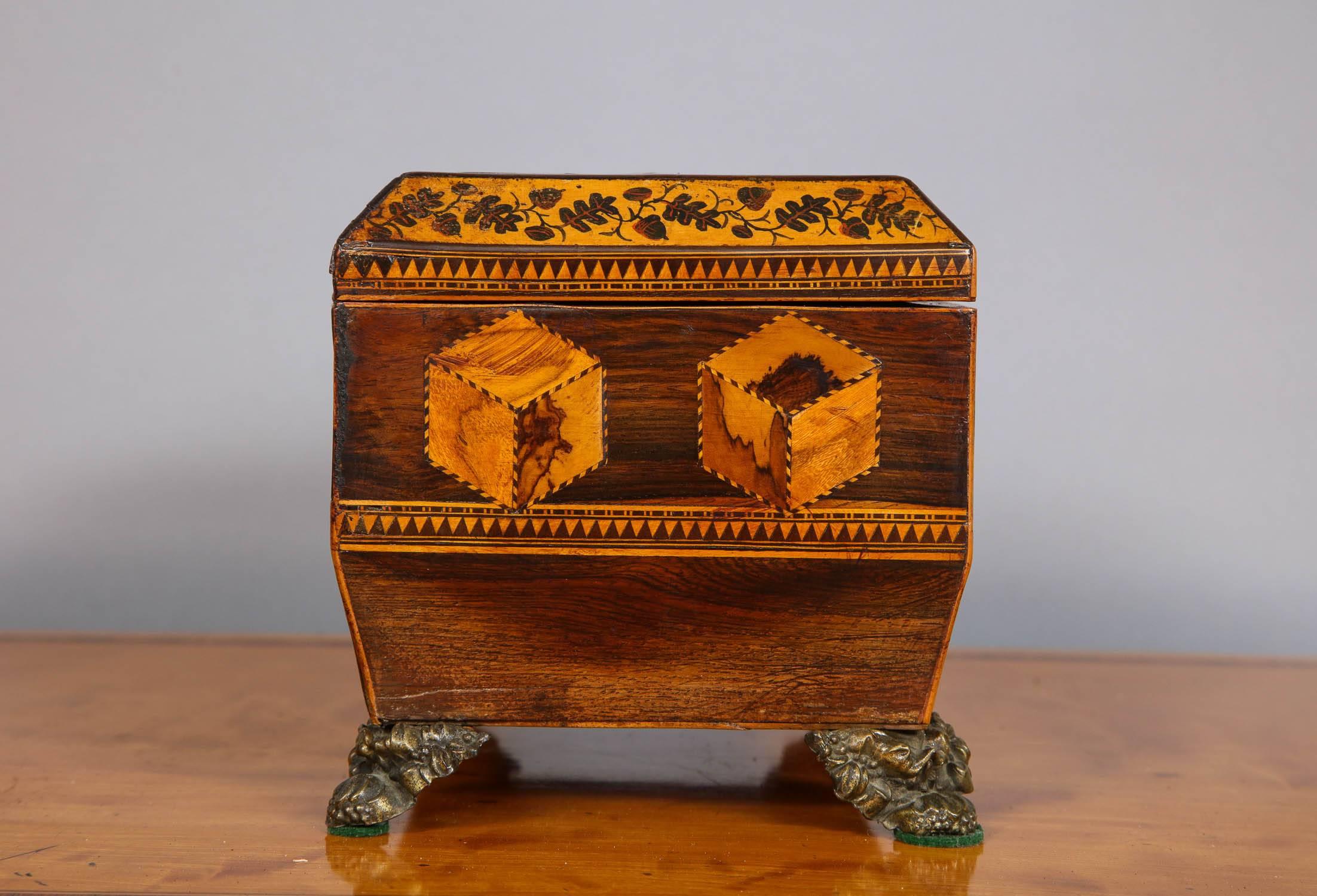 Fine early 19th century Tunbridge ware tea caddy, the top inlaid with geometric patterns, the canted sides with wood mosaic ivy banding over further geometric inlay, standing on gilt brass feet, the whole with good rich color and