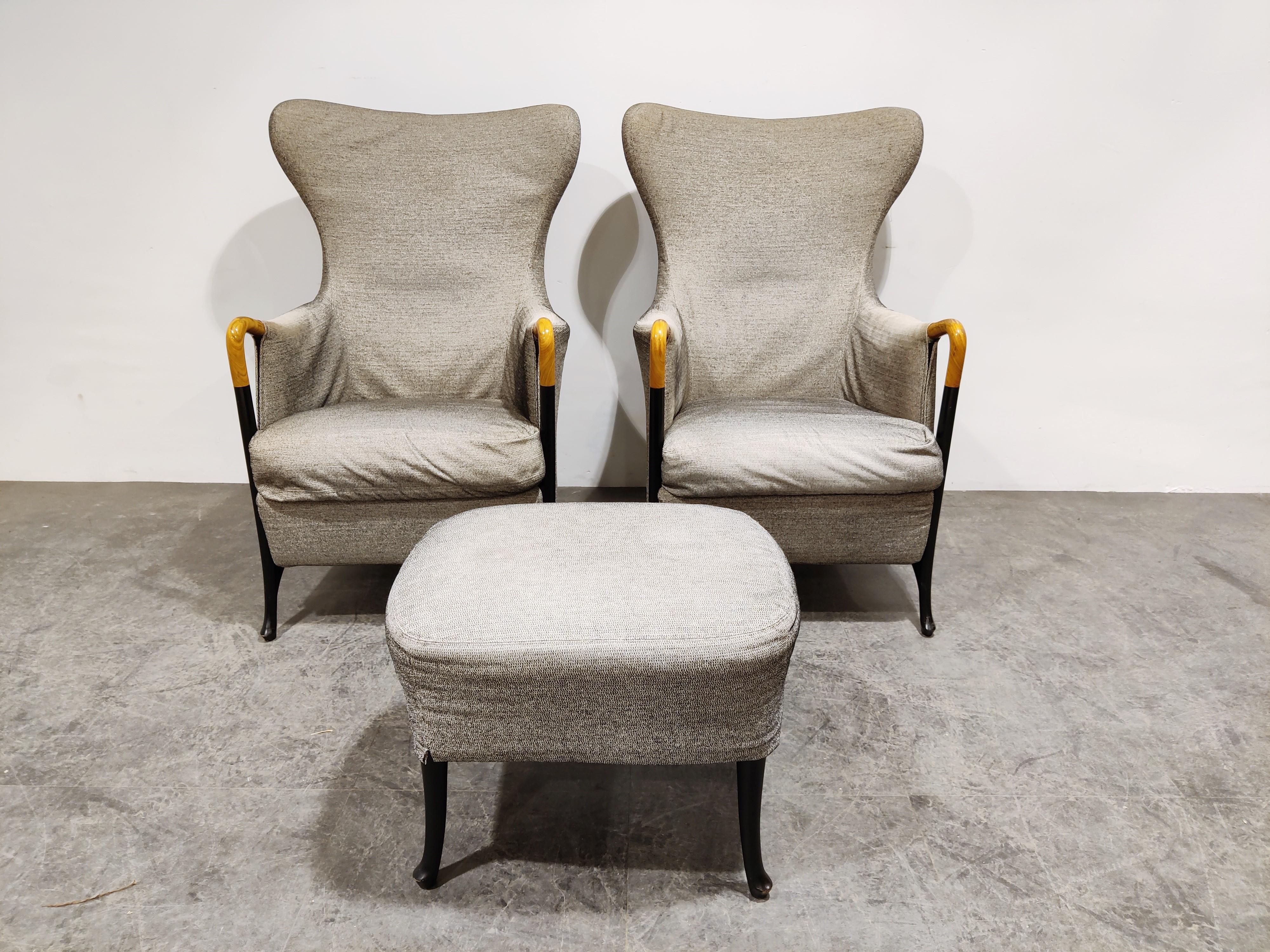 Set of two wingback model progretti armchairs designed by Umberto Asnago for Giorgetti with footstool.

Elegant italian design with the beautiful integrated wooden armrest and the black lacquered frame.

The chairs have a light grey