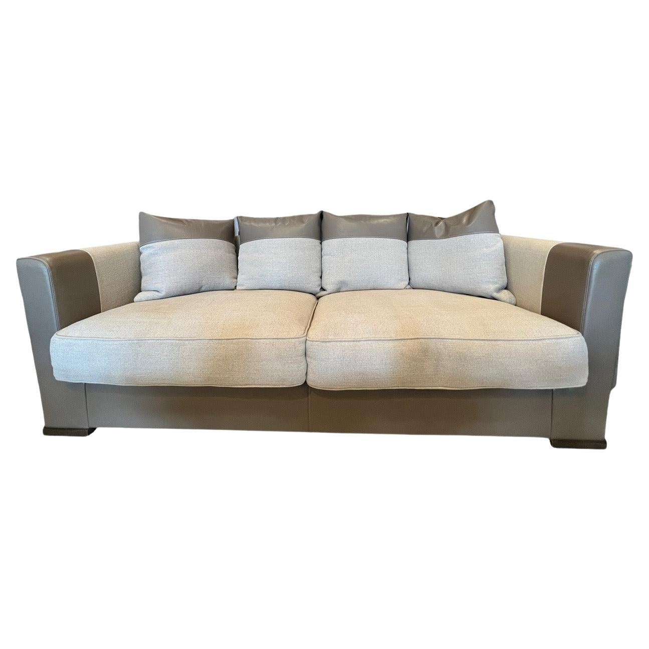 Behold the Promemoria Dolce Vita Sofa, a masterpiece that boasts a dual essence—the tactile harmony of fabric and leather. This sofa represents a symphony of contrasting sensations, seamlessly blending non-removable fabric with exquisite leather