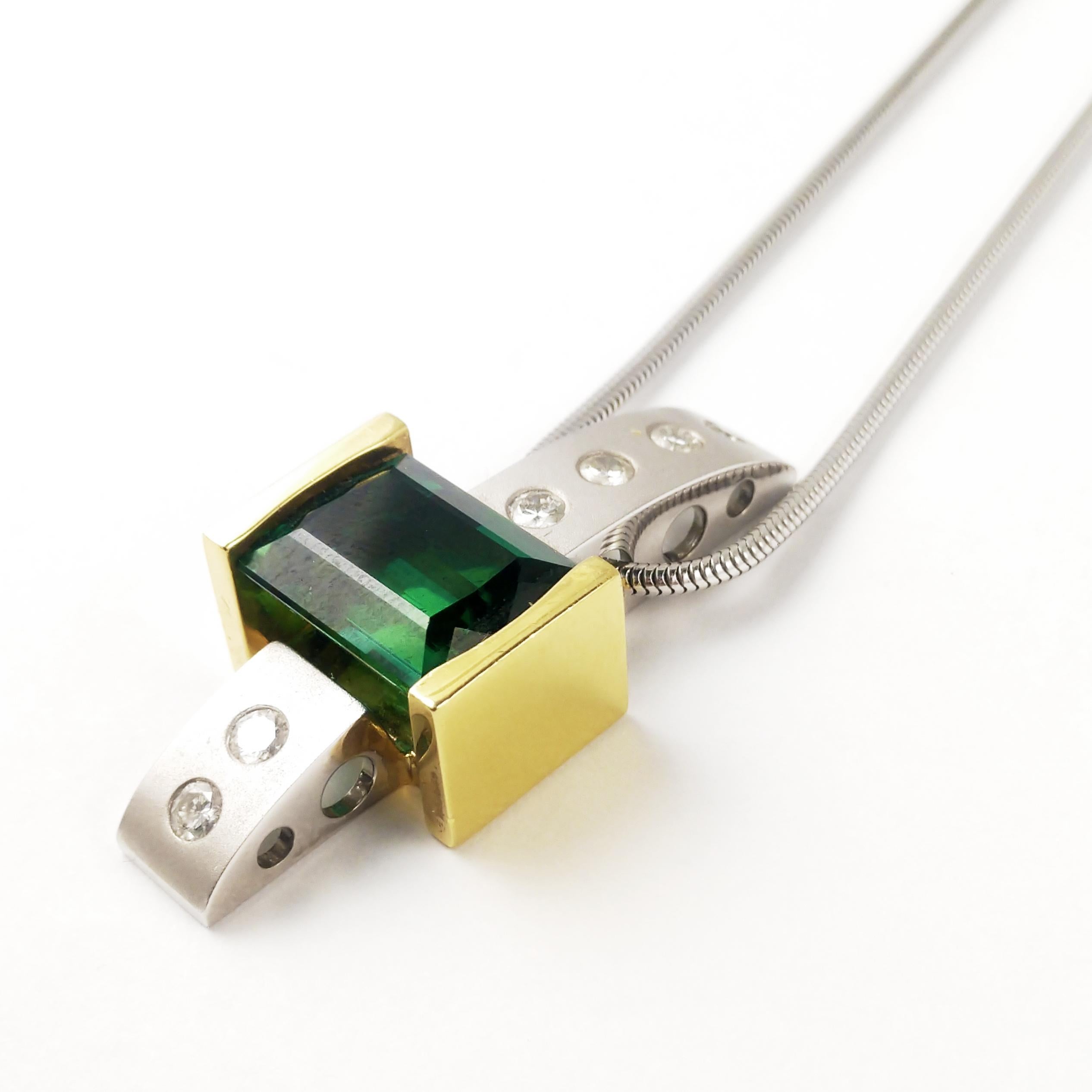 Modern, and streamlined, Cornelis Hollander’s visionary creations are among the world’s most sought-after designs. This necklace features a rectangle green tourmaline that weighs 10.48ct of excellent quality and measure 10.6 x 3.2 mm. The flush-set