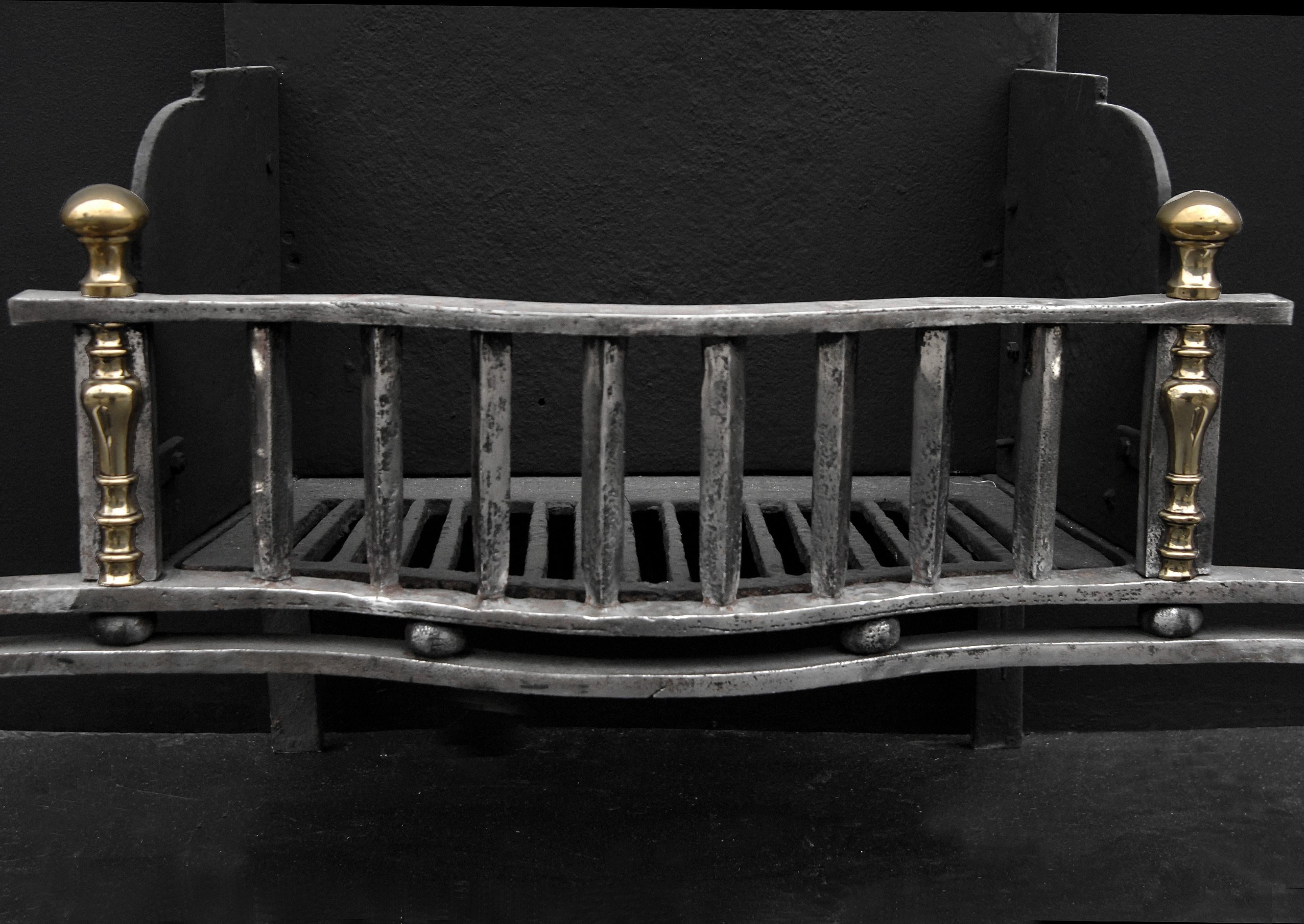 Prominent mid 19th century English polished wrought iron firegrate, with barleytwist and scrolled legs, surmounted by brass ball finials. The uprights also with brass finials either side. Shaped back.

Width At Front:	985 mm      	38 ¾