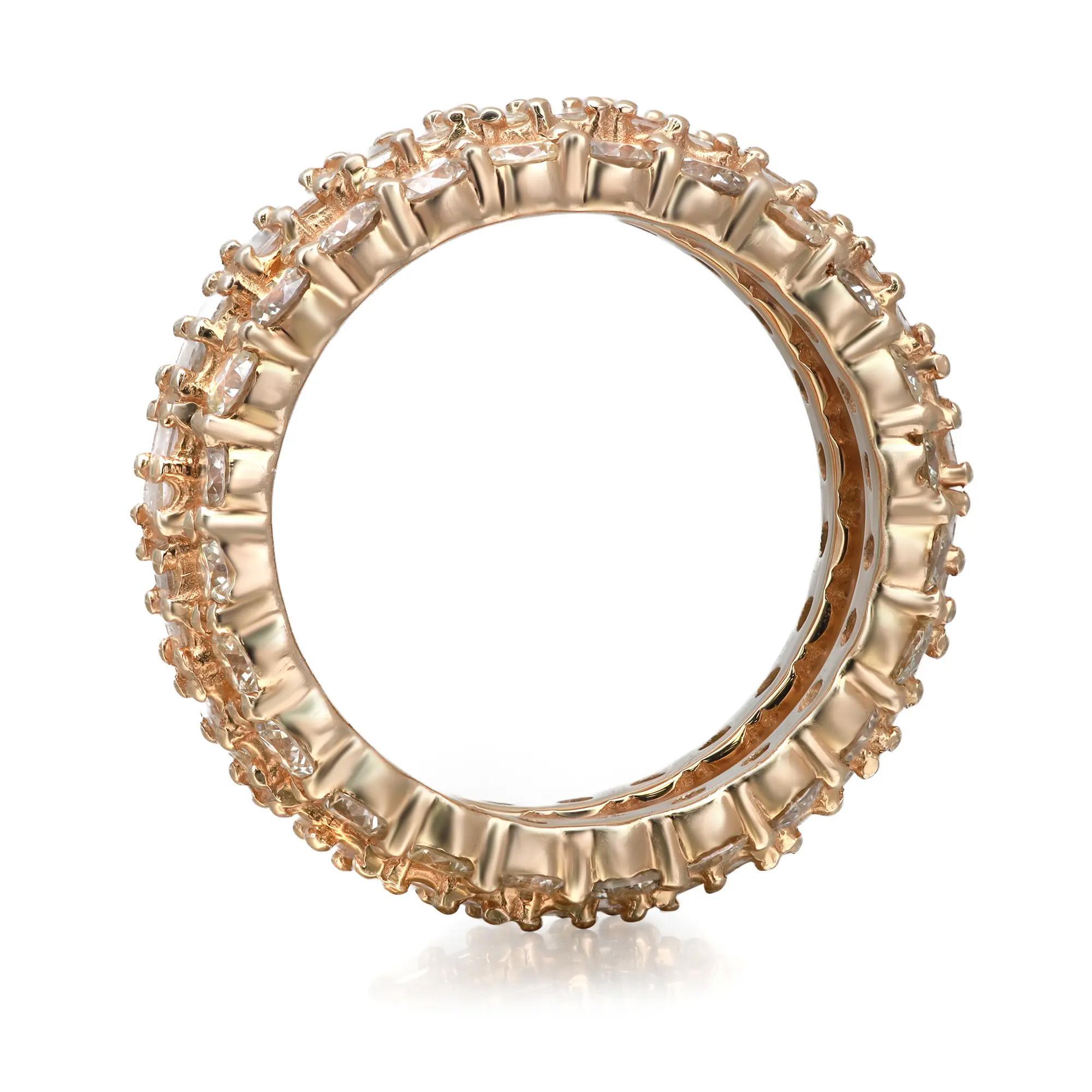 This stunning band ring features prong set baguette cut diamonds as a center row with round brilliant cut diamonds outlining on the both sides. The stones are beautifully circling all the way around the band and are set in fine 14k yellow gold.