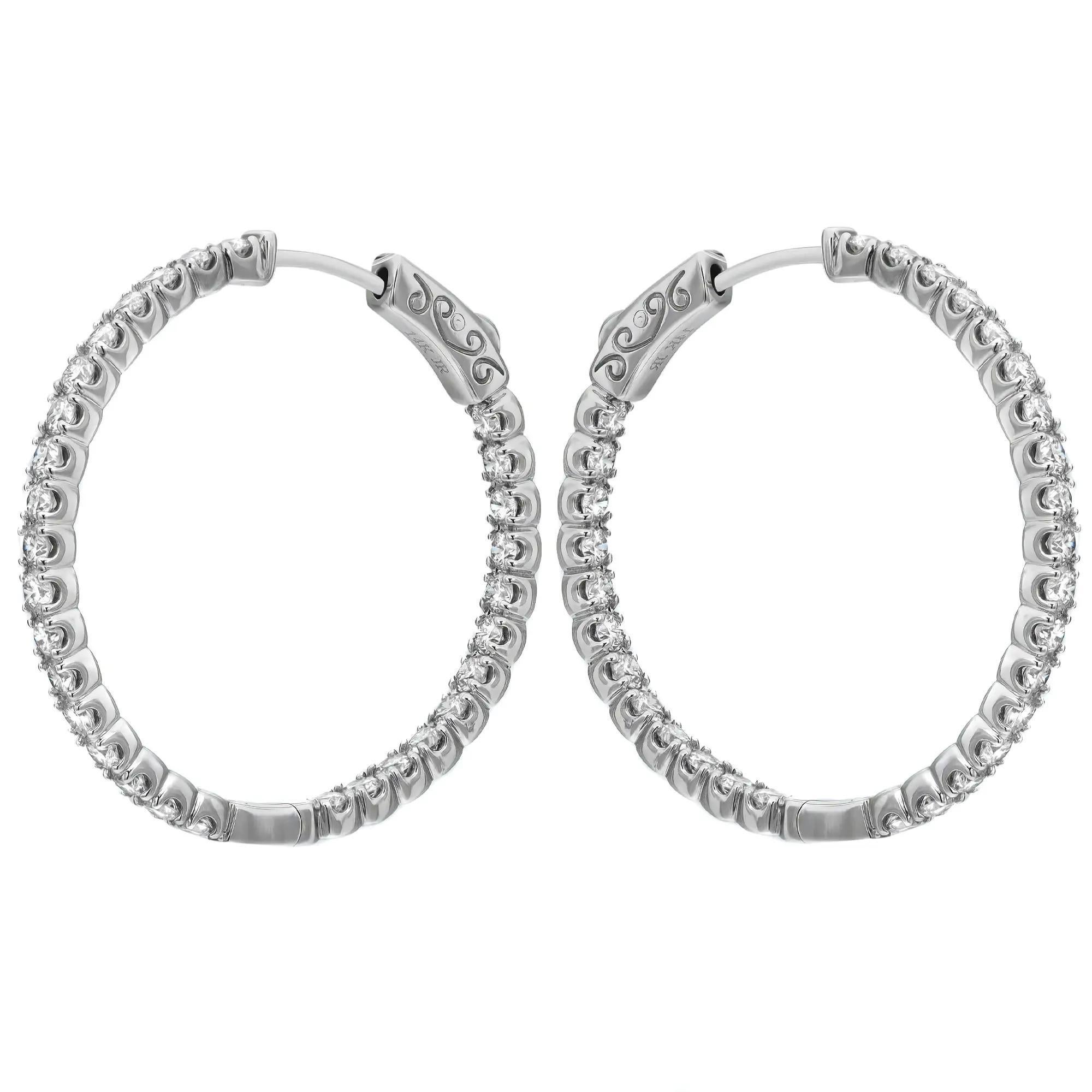 Elevate any attire with these dazzling diamond hoop earrings. Crafted in 14K white gold, each earring sparkles from every angle with a row of glistening diamonds studded inside and outside of the hoop. Total diamond weight: 2.35 carats. Each diamond
