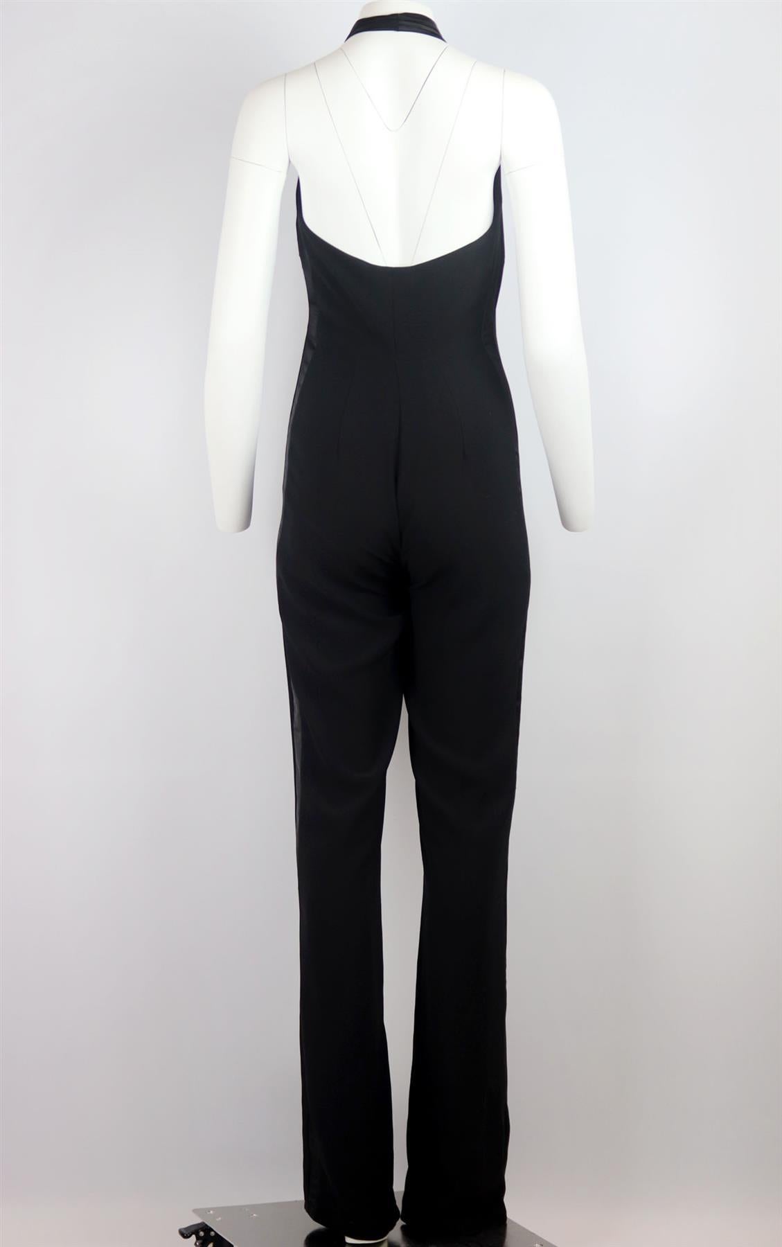 If dresses aren't typically your thing, then why wear one, a modern take on '70s styles, Pronovias's jumpsuit is made from black crepe with satin trimming and finished with beaded faux button detail like a tuxedo. Black crepe, black satin. Concealed