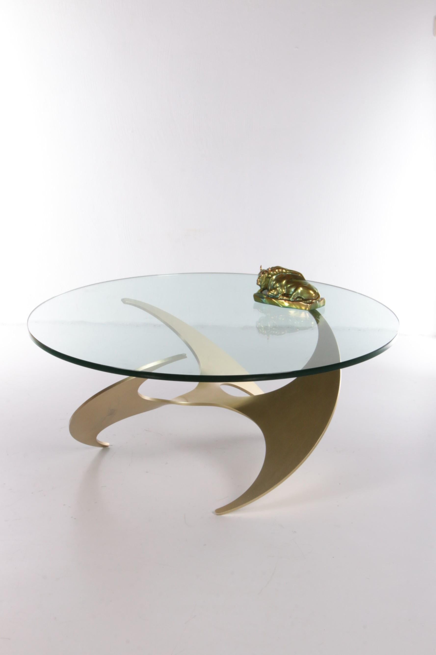 A beautiful aluminum and glass Propeller Coffee table by Knut Hesterberg for the designer brand Ronald Schmitt. Produced in the 60s.

A very nice coffee or cocktail table in the shape of a propeller made of aluminum. The round table top is made of
