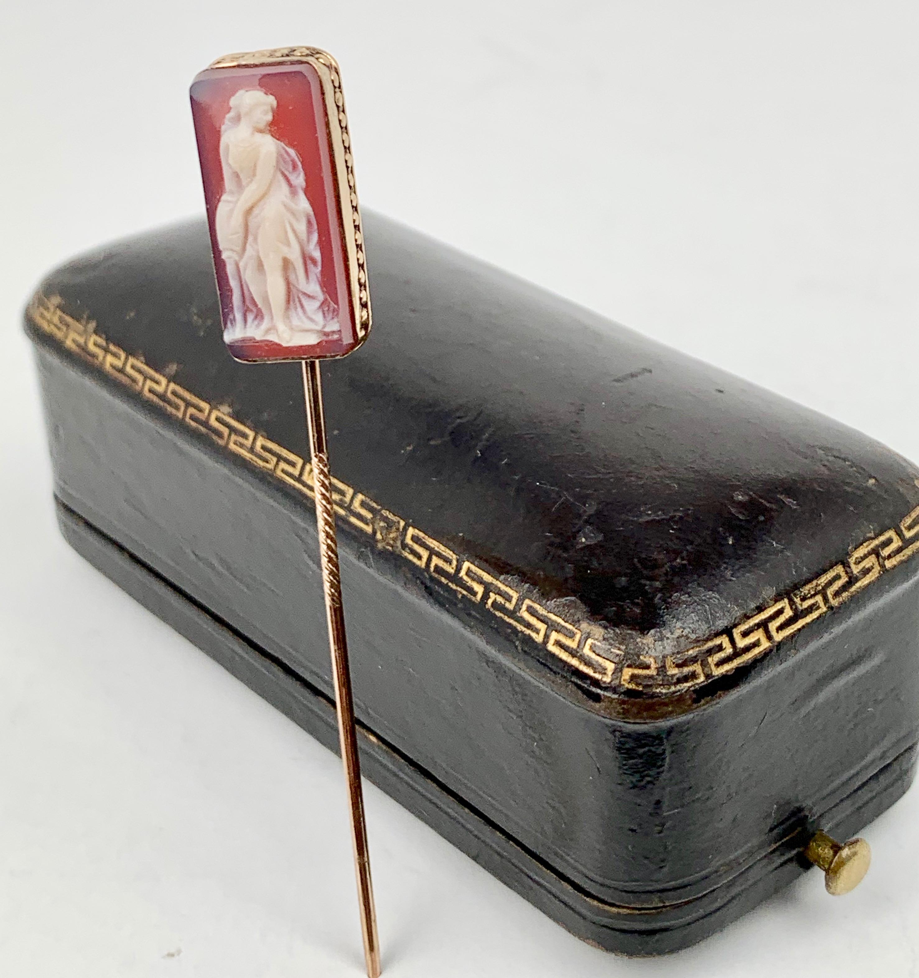 Once worn by Nat King Cole this agate cameo and gold stickpin still rests in its original leather presentation case gold tooled with a greek key pattern.  The subject is the classical Greek female figure poring water from a jug.